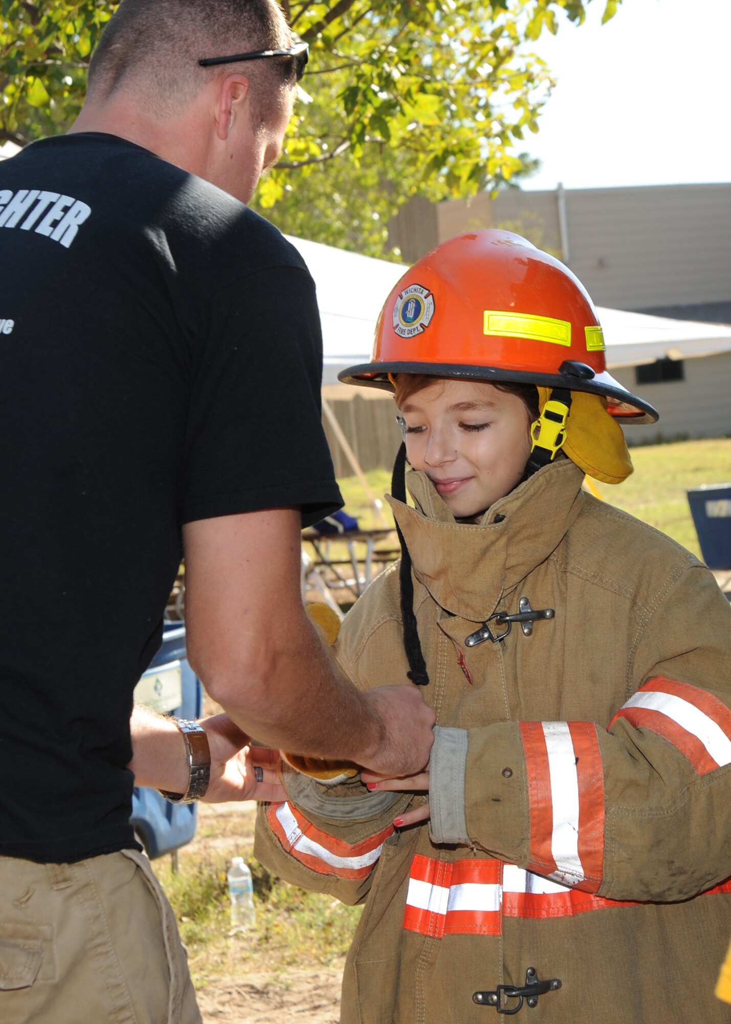 Airman 1st Class Nick Sanchez, 22nd Civil Engineer Squadron firefighter, assists 10-year old Dominique Kyle, McLean Elementary School student, with putting on a firefighter suit during the Fire Prevention Extravaganza held at the Sedgewick County Zoo, Oct. 5, 2010, Wichita, Kan.  The event introduced children from the local community to McConnell’s fire department and educated children about fire safety and prevention.  (U.S. Air Force photo/Airman 1st Class Andrea Salazar)