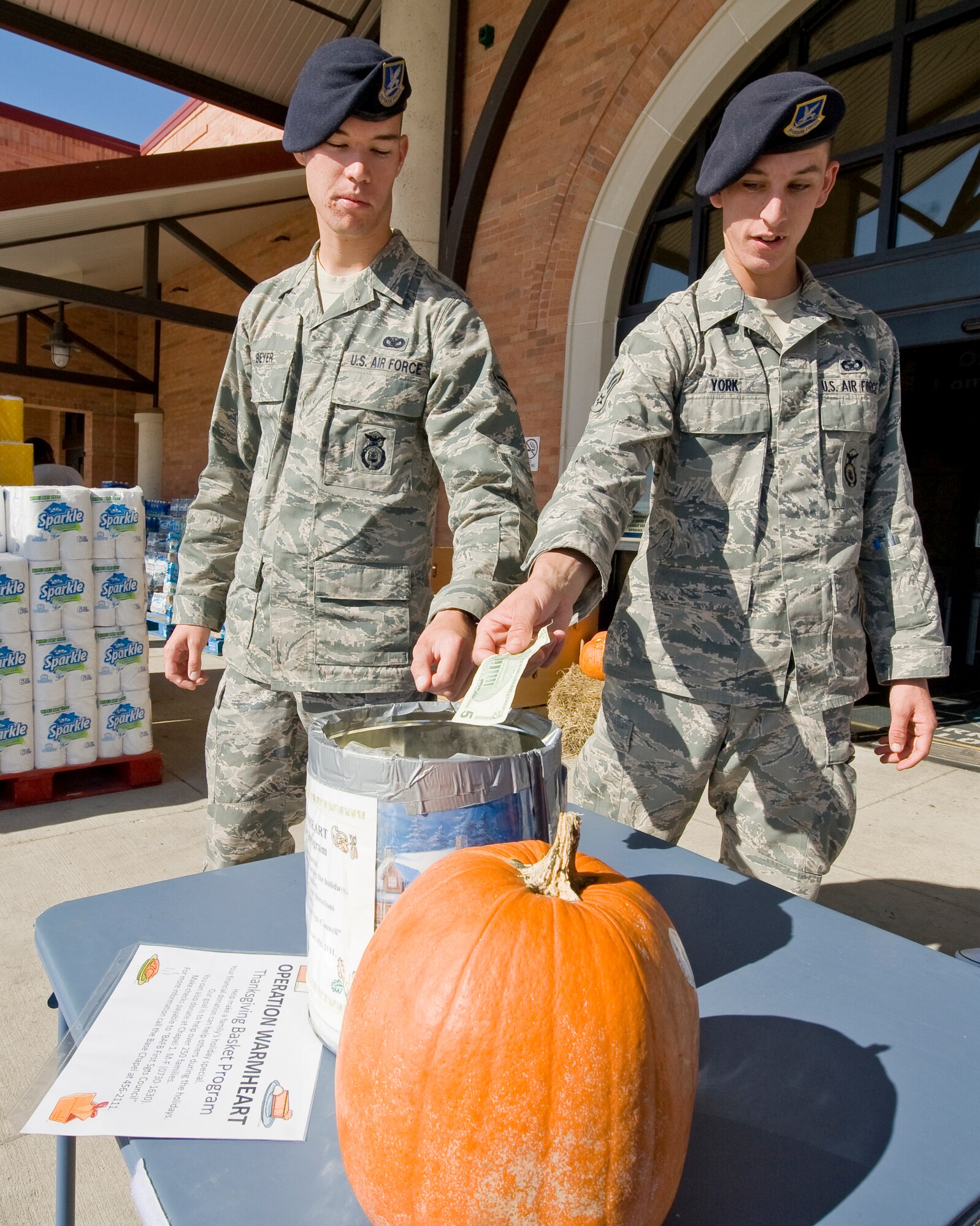 BARKSDALE AIR FORCE BASE, La. -- Two security forces Airmen donate money to Operation Warmheart outside the Commissary Oct. 6. Operation Warmheart is a program that provides for Airmen and their families who may need financial help during the holidays. (U.S. Air Force photo/Senior Airman Chad Warren)