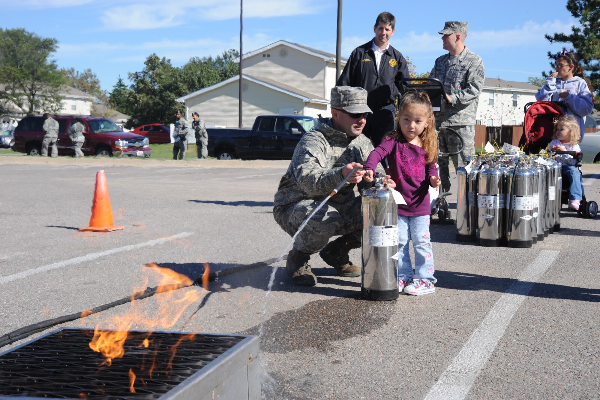 Senior Airman Thomas Barina, 22nd Civil Engineer Squadron firefighter, shows Elizabeth Galloway, 3, how to extinguish a fire with a fire extinguisher Oct. 2, 2010, McConnell Air Force Base, Kan.  The fire department hosted the sixth annual Fire Prevention Extravaganza at McConnell family housing.  The event had several fire safety demonstrations and activities.  “Smoke Alarms: A Sound You Can Live With!” is the theme for the nationwide Fire Prevention Week campaign, which runs from Oct. 3 through 9.   (U.S. Air Force photo/Staff Sgt. Dallas Edwards)