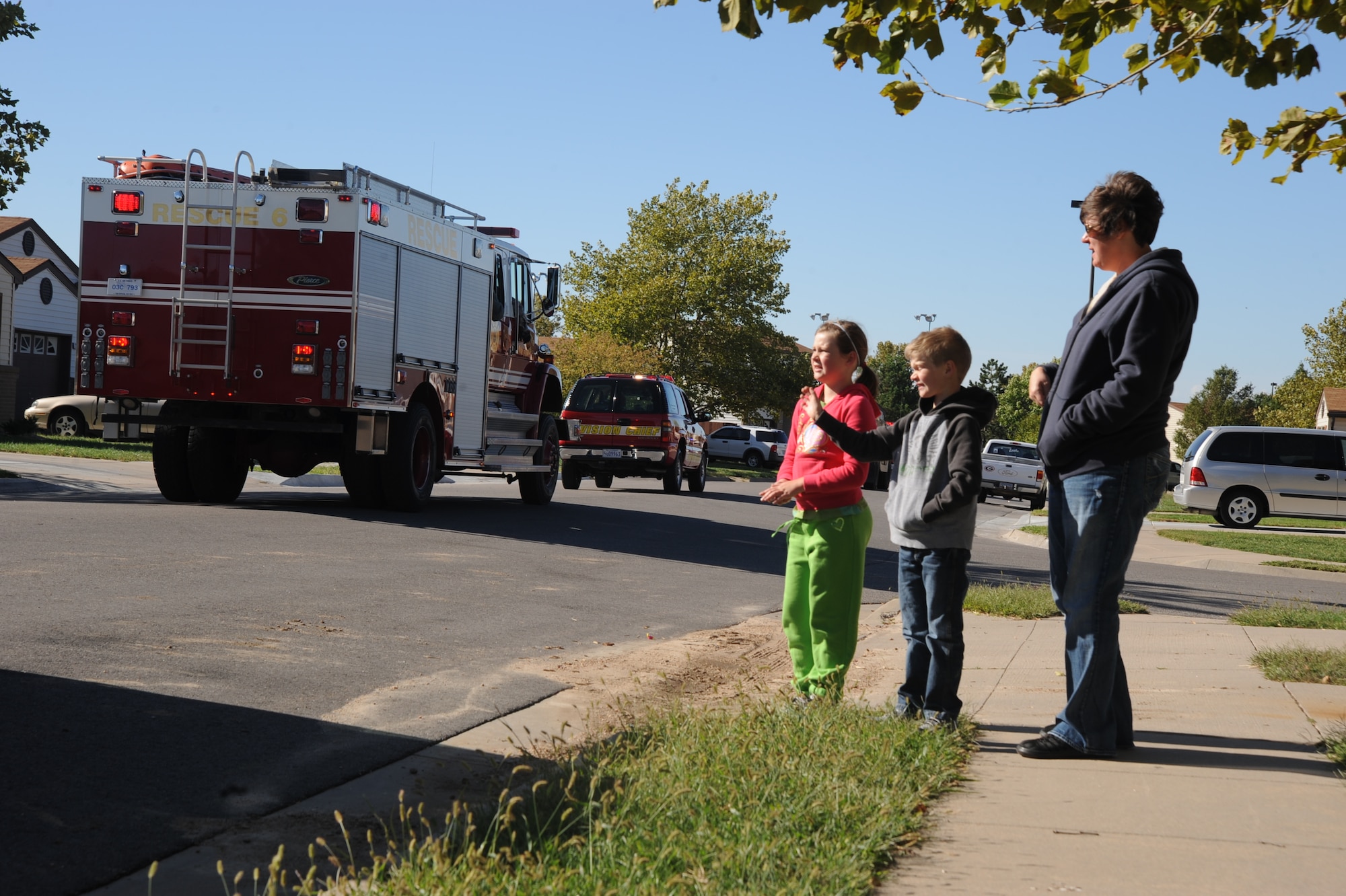 Emma Kranz, 8, Jahse Kranz, 6, and their mother Stacy Kranz, 22nd Medical Operations Squadron registered nurse, watch Fire Prevention Week kick-off parade at McConnell family housing, Oct. 2, 2010, McConnell Air Force Base, Kan.  After the parade, the base fire department hosted the sixth annual Fire Prevention Extravaganza where they had educational activities for kids and fire safety demonstrations.  “Smoke Alarms: A Sound You Can Live With!” is the theme for the nationwide 2010 Fire Prevention Week campaign, which runs from Oct. 3 through 9.   (U.S. Air Force photo/Staff Sgt. Dallas Edwards)