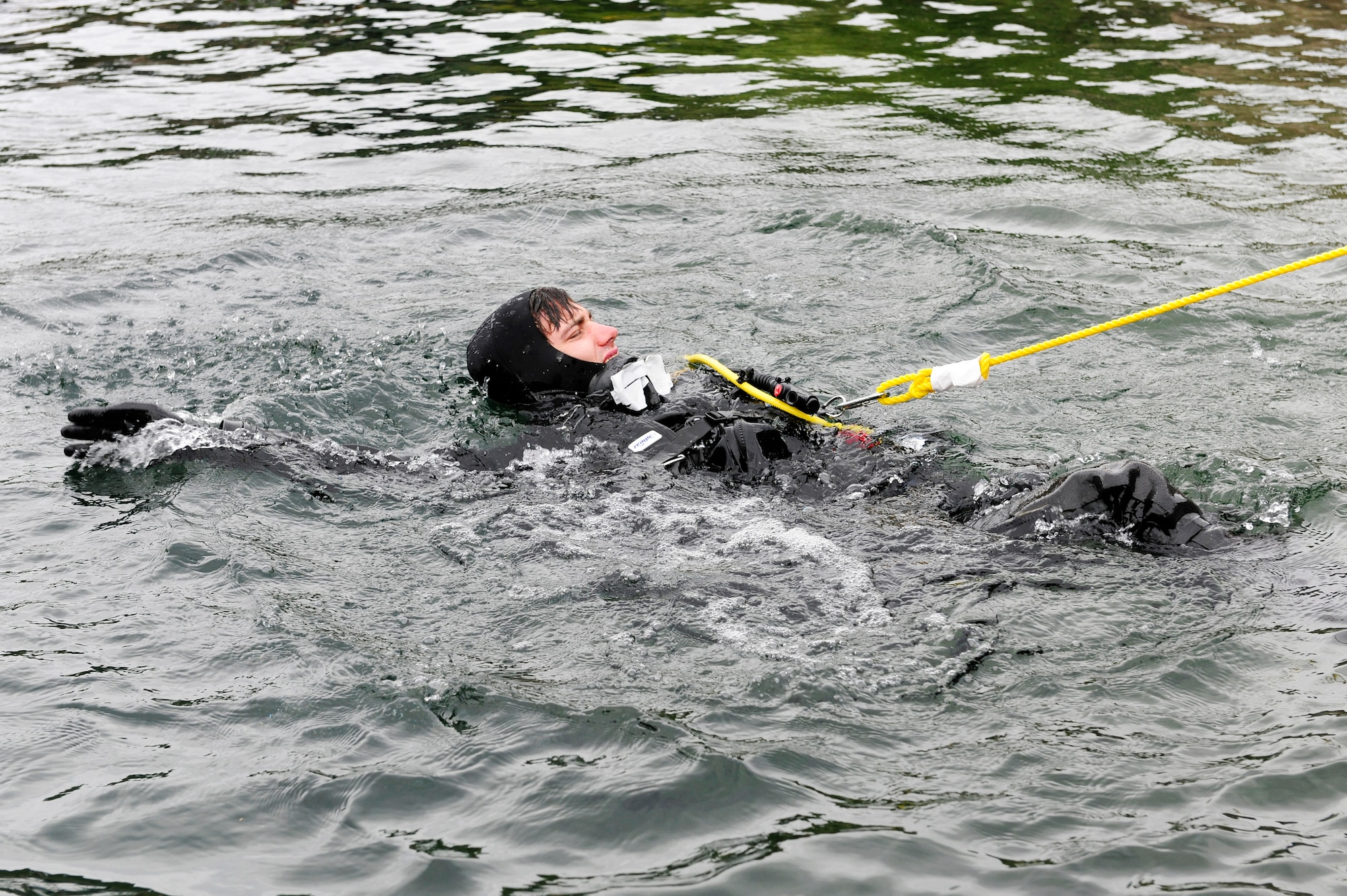 STONEY COVE, England – Senior Airman Eli Reynolds, 56th Rescue Squadron pararescueman, pulls tension on the line while surface swimming to his descent point for subsurface search, rescue and recovery training Oct. 5. Before descending, dive instructors observe the diver for possible bubbles in their air manifolds. (U.S. Air Force photo/Airman 1st Class Lausanne Morgan)