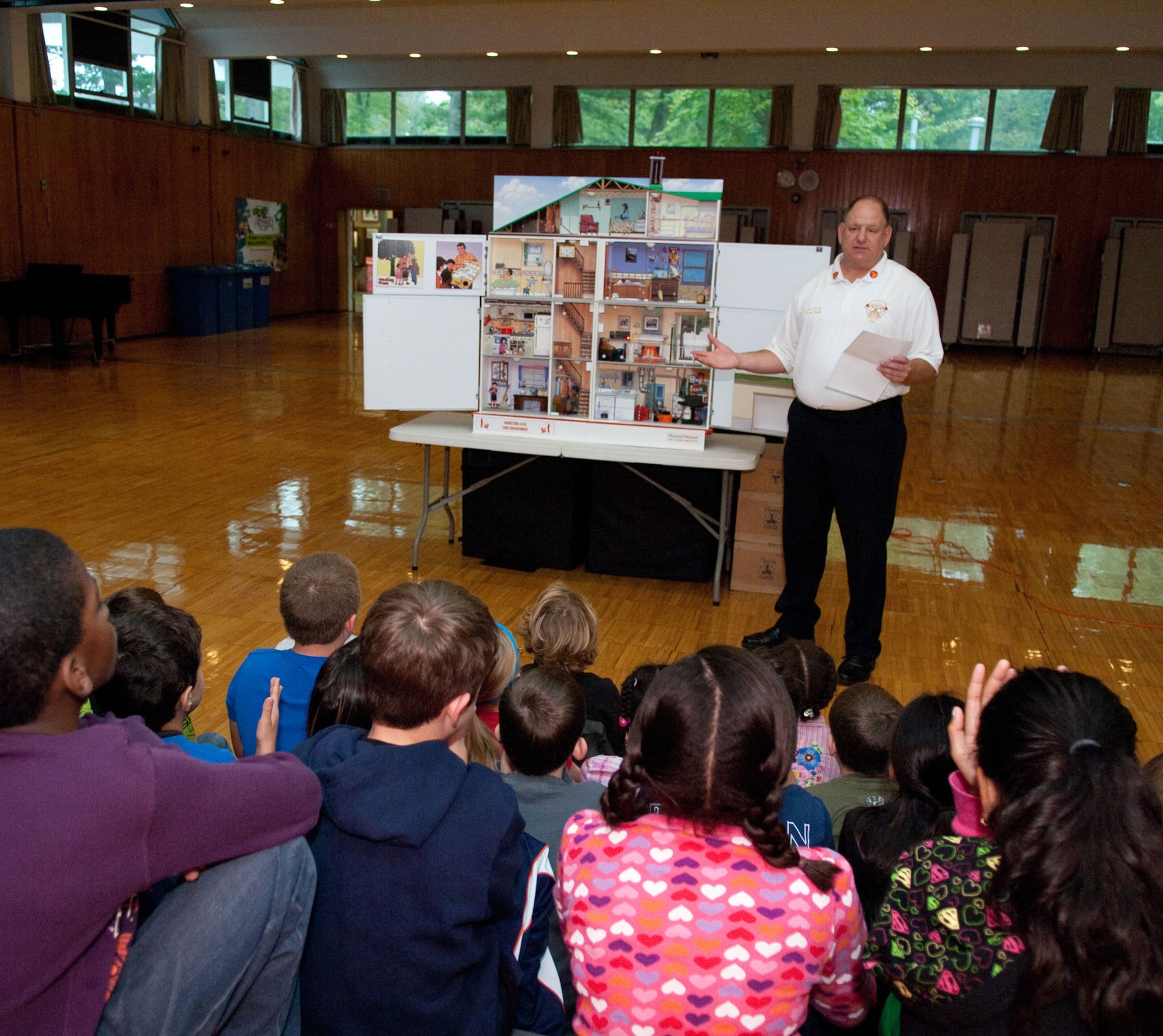 HANSCOM AIR FORCE BASE, Mass. – As part of Fire Prevention Week, Assistance Fire Chief Mark Webb explains parts of the Hazard House to fourth and fifth graders at Hanscom Middle School on Oct. 5. The Hazard House has several built in fire hazards that produce sound, lights and smoke to educate children about fire safety. (U.S. Air Force photo by Rick Berry)