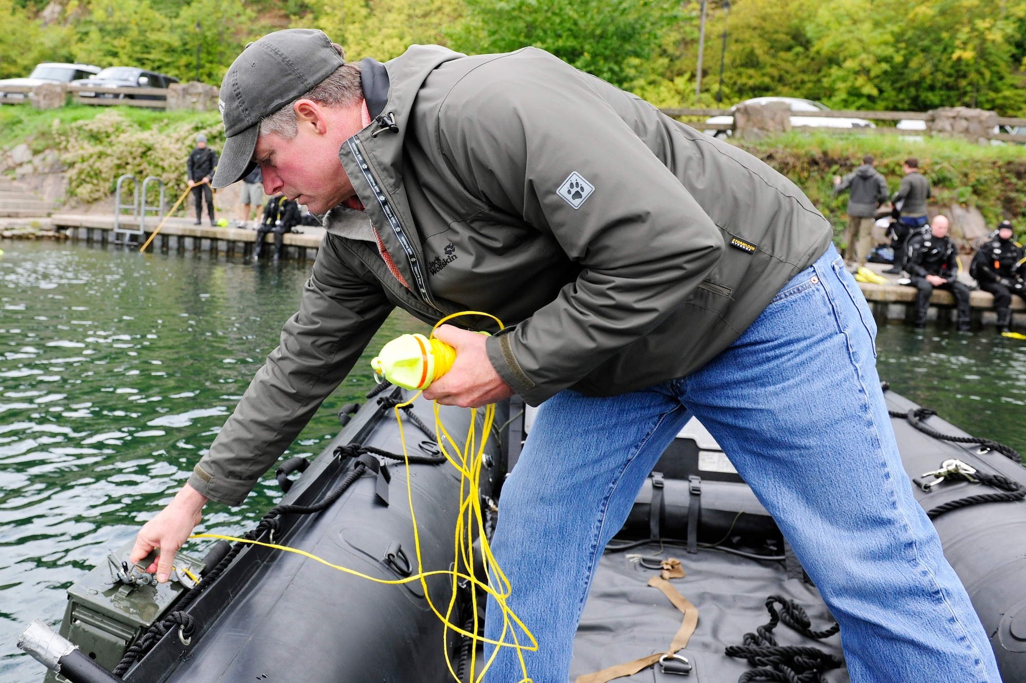 STONEY COVE, England – Retired Master Chief Petty Officer Doug Westling, 56th Rescue Squadron master diver, places an ammunition can into the water during rescue dive training Oct. 5. For training purposes, white tape was placed over goggles to simulate low visibility when locating and retrieving submerged sensitive materials.  (U.S. Air Force photo/Airman 1st Class Lausanne Morgan)