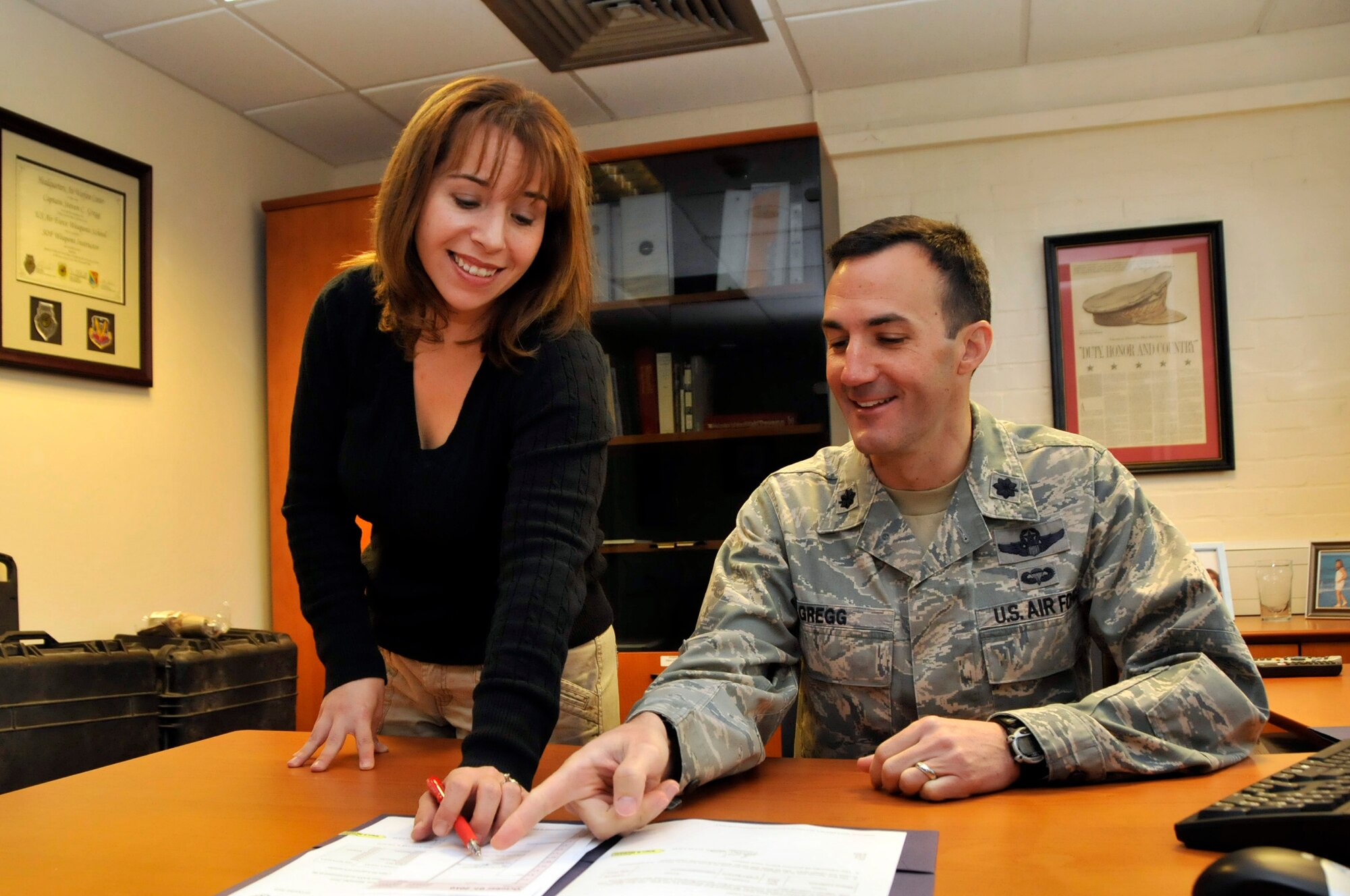 Jen Holtz,56th Rescue Squadron commander’s secretary, looks over scheduling with Lt. Col. Steven Gregg, 56th RQS commander Oct. 6. Holtz was nominated for a Liberty Spotlight because she displays the core value of 'Excellence in All We Do'. (U.S. Air Force photo.Airman 1st Class Eboni Knox)