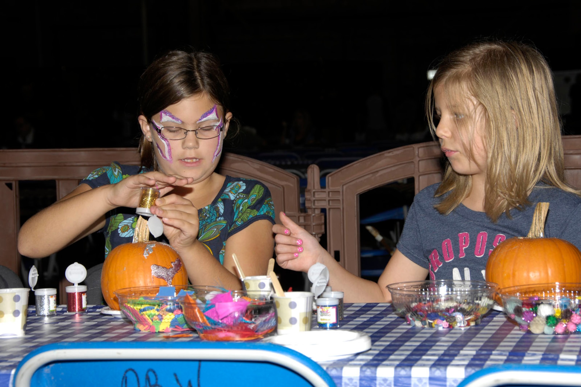 HANSCOM AIR FORCE BASE, Mass. - Emma Black (left) and Gina Peterson decorate pumpkins during Oktoberfest at the Aero Club Hangar on Oct. 1. Oktoberfest featured German-themed food such as bratwursts and sauerkraut, the Mad Bavarian Brass Band that played German-style music, pumpkin decorating, vendors and games and activities for kids. (U.S. Air Force photo by Linda LaBonte Britt) 