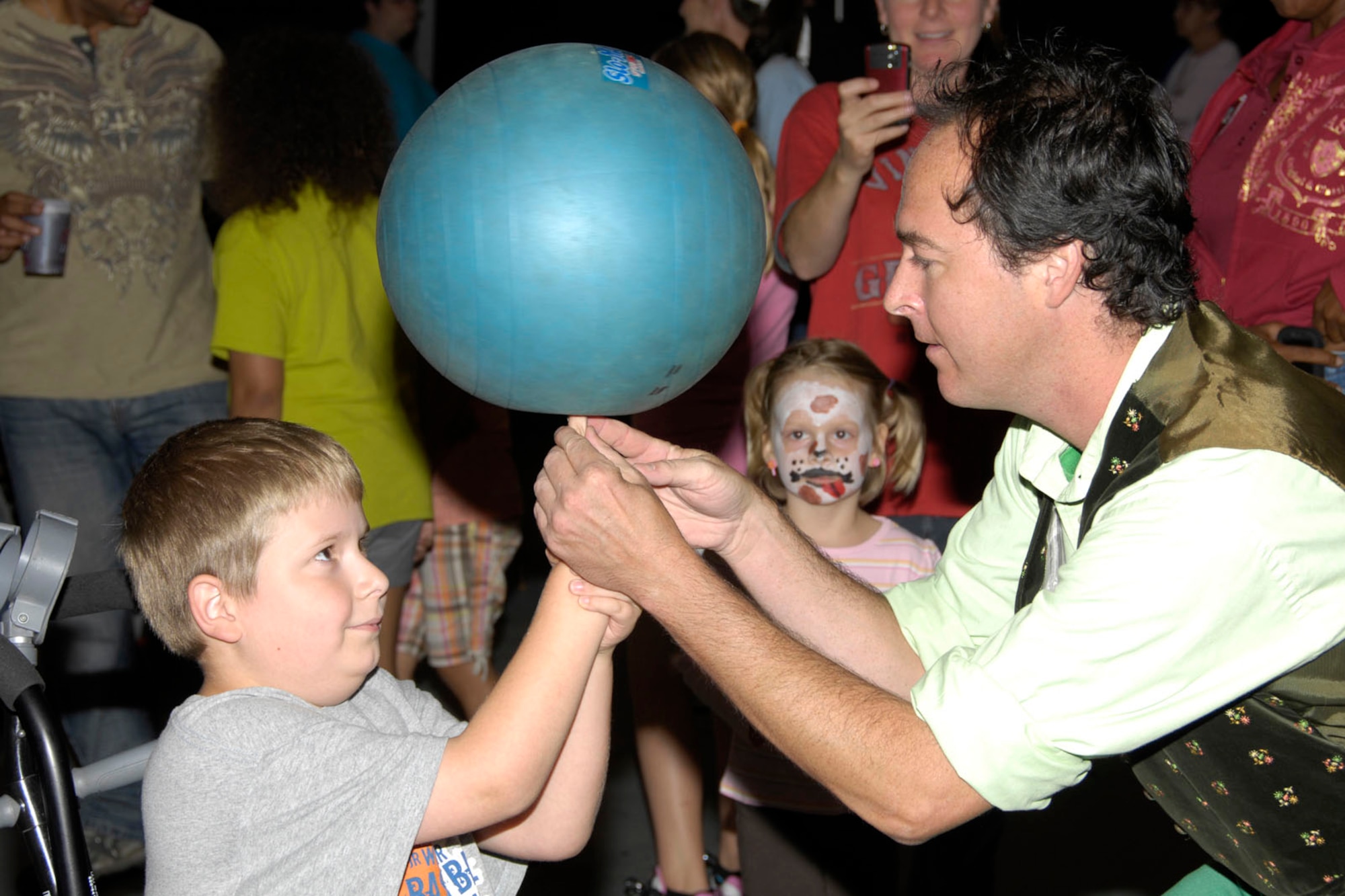 HANSCOM AIR FORCE BASE, Mass. – Juggler Peter Panic (right) helps Jakob Gorton learn how to balance a spinning ball on his finger during Oktoberfest in the Aero Club Hangar on Oct. 1. Oktoberfest featured German-themed food such as bratwursts and sauerkraut, the Mad Bavarian Brass Band that played German-style music, pumpkin decorating, vendors and games and activities for kids. (U.S. Air Force photo by Linda LaBonte Britt) 
