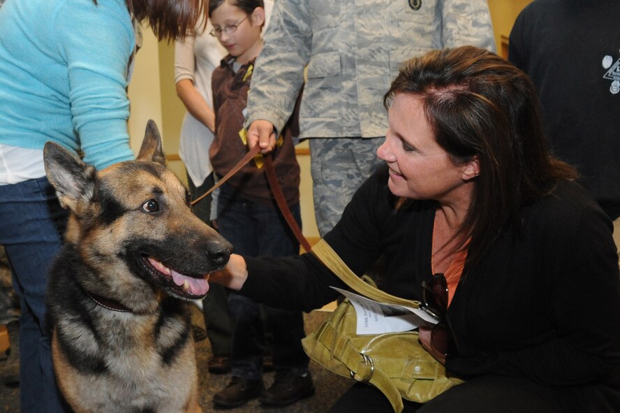 Angie Baumann, a Grand Forks Chamber of Commerce leadership tour participant, pets former military working dog Nick/J252’s head after his retirement ceremony Oct. 6 at Heritage Hall on Grand Forks Air Force Base. Mrs. Baumann is part of the Grand Forks Chamber’s yearly leadership class for rising leaders within the community to educate them on various aspects of leadership. The base tour showcased different types of military leadership and training such as the Airman Leadership School and the first term airman center. (U.S. Air Force photo by Tech. Sgt. Johnny Saldivar)