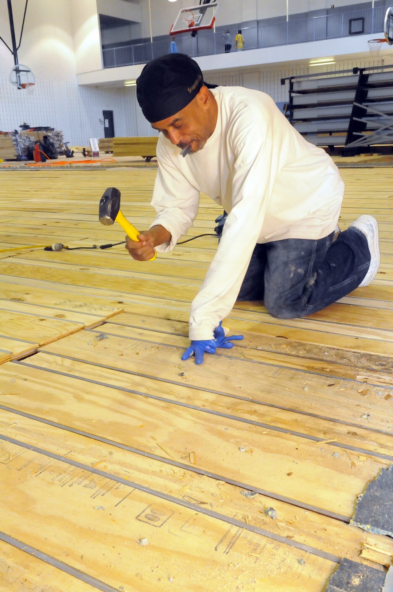 John Glass, CBA Sports employee, works on the subfloor of the gym at the fitness center. U. S. Air Force photo by Sue Sapp