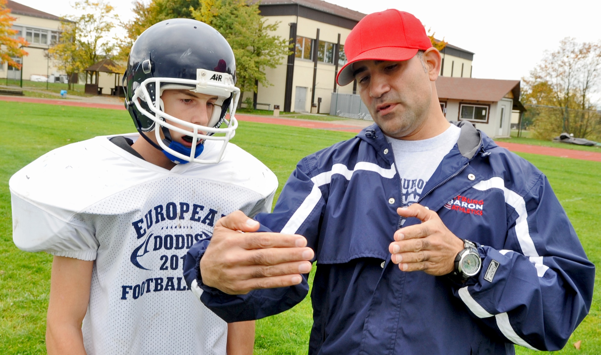 SPANGDAHLEM AIR BASE, Germany - Tech. Sgt. Erick Matos, 52nd Operations Support Squadron and a coaching staff member for the Bitburg High School Baron football team, coaches Nick Reuter, BHS freshman, on stopping a field goal kick Oct. 5. Sergeant Matos currently volunteers approximately 15 hours a week to help his 17 year-old-son’s high school football team. (U.S. Air Force photo/Senior Airman Nick Wilson)