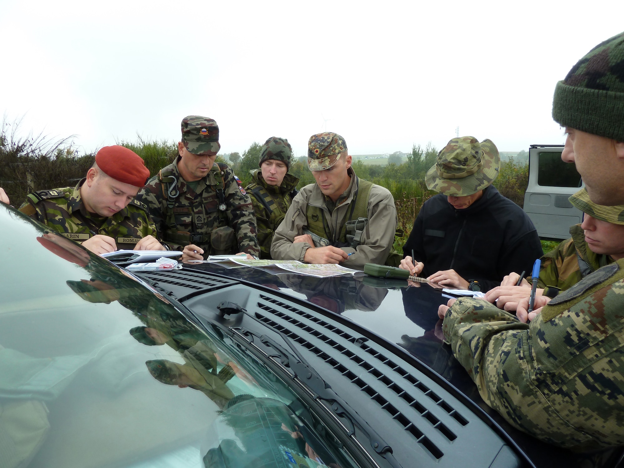 BANN, Germany -- German air force Maj. Bernd Vellman (center), an instructor at the U.S. Air Forces in Europe Air Ground Operations School, prepares six NATO students before they call in practice airstrikes during a field training exercise Sept. 28, 2010. The USAFE AGOS conducts a five-week initial training course for U.S. and NATO joint terminal attack controllers. The countries participating in the training course are U.S., Slovenia, Belgium, Estonia, Romania, Norway, Croatia, Poland and Latvia. (U.S. Air Force photo/Tech. Sgt. Francesca Popp)