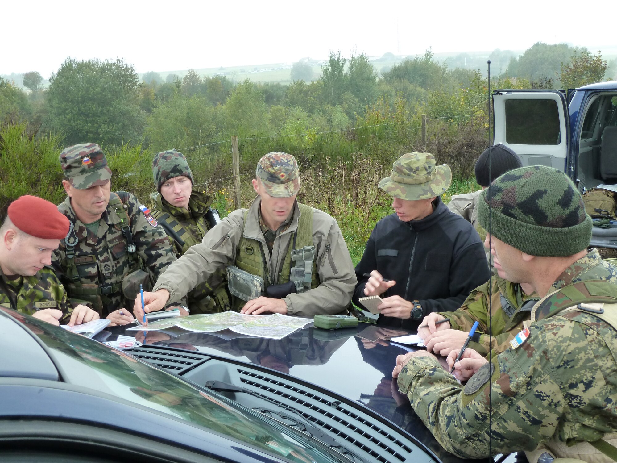 BANN, Germany -- German air force Maj. Bernd Vellman (center), an instructor at the U.S. Air Forces in Europe Air Ground Operations School, prepares six NATO students before they call in practice airstrikes during a field training exercise Sept. 28, 2010. The USAFE AGOS conducts a five-week initial training course for U.S. and NATO joint terminal attack controllers. The countries participating in the training course are U.S., Slovenia, Belgium, Estonia, Romania, Norway, Croatia, Poland and Latvia. (U.S. Air Force photo/Tech. Sgt. Francesca Popp)
