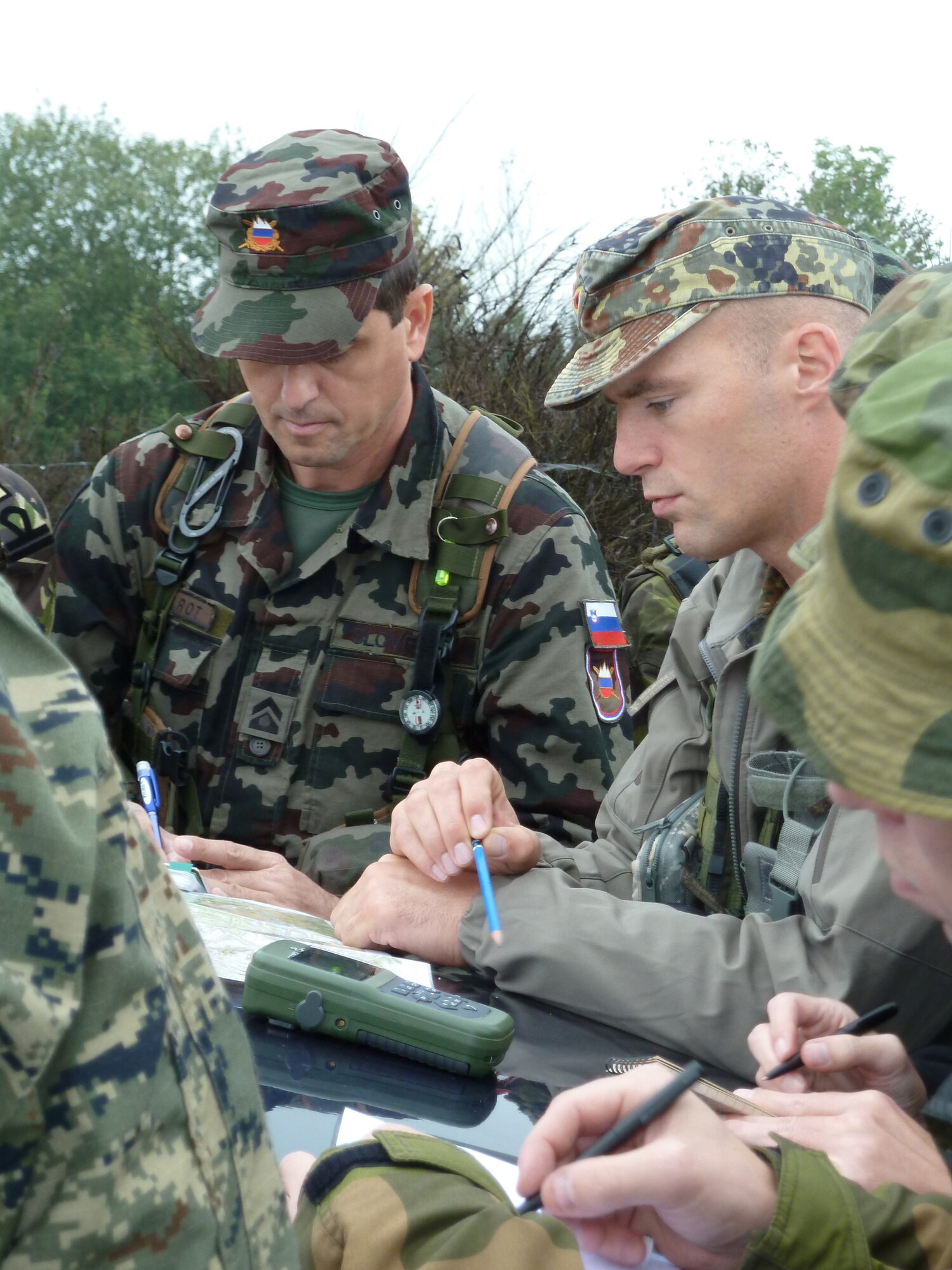 BANN, Germany -- German air force Maj. Bernd Vellman (right), an instructor at the U.S. Air Forces in Europe Air Ground Operations School, prepares NATO students before they call in practice airstrikes during a field training exercise Sept. 28, 2010.  The USAFE AGOS conducts a five-week initial training course for U.S. and NATO joint terminal attack controllers. The countries participating in the training course are U.S., Slovenia, Belgium, Estonia, Romania, Norway, Croatia, Poland and Latvia. The first class for fiscal 2011 is scheduled to graduate Oct. 8. (U.S. Air Force photo/Tech. Sgt. Francesca Popp)