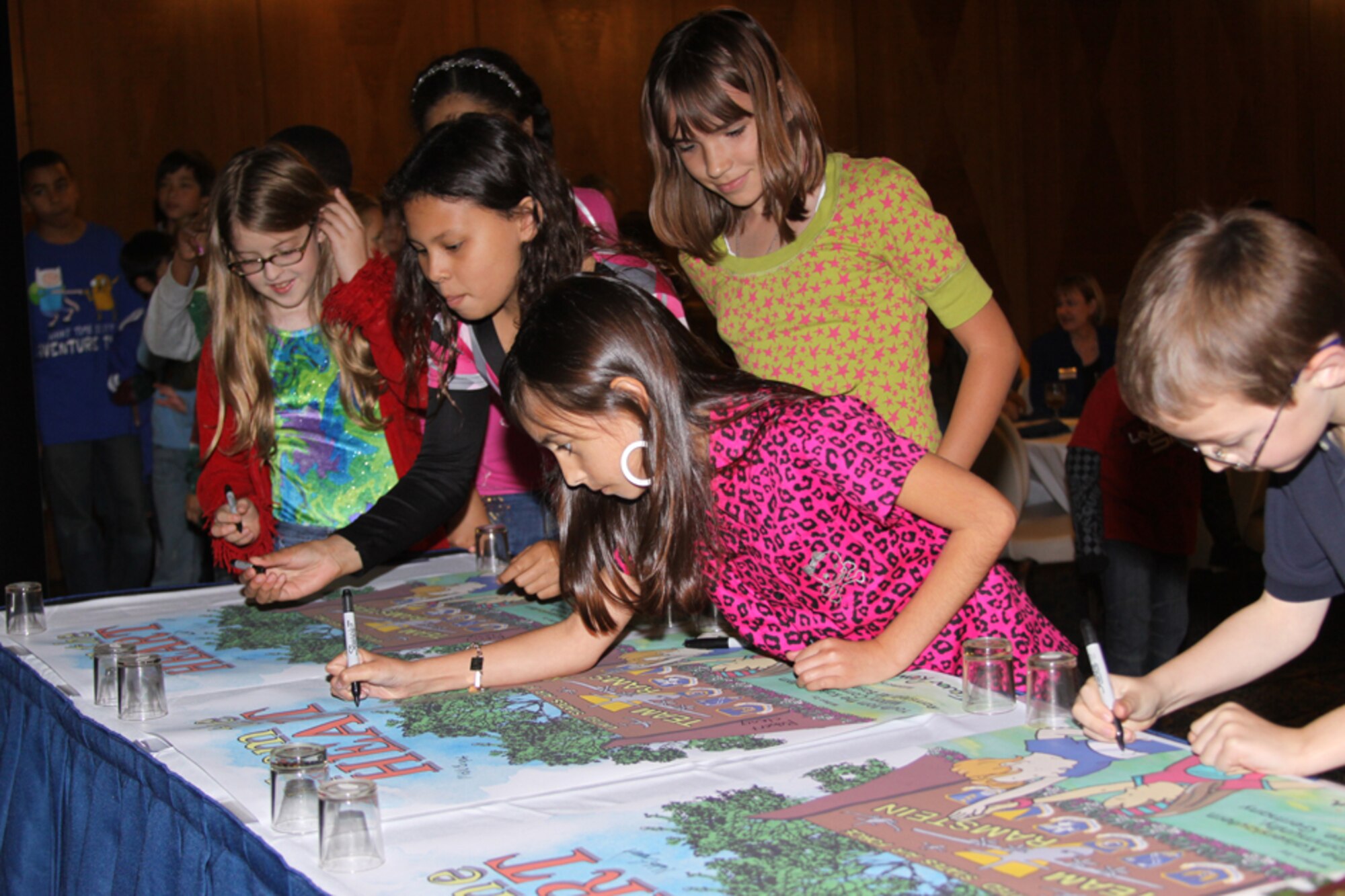 Some of the authors of 'From the Heart, (from left) Isabelle Trautman, Raisa Wargel, Maddie Morse, Ally Hensley, Ryan Clancy sign book posters.
