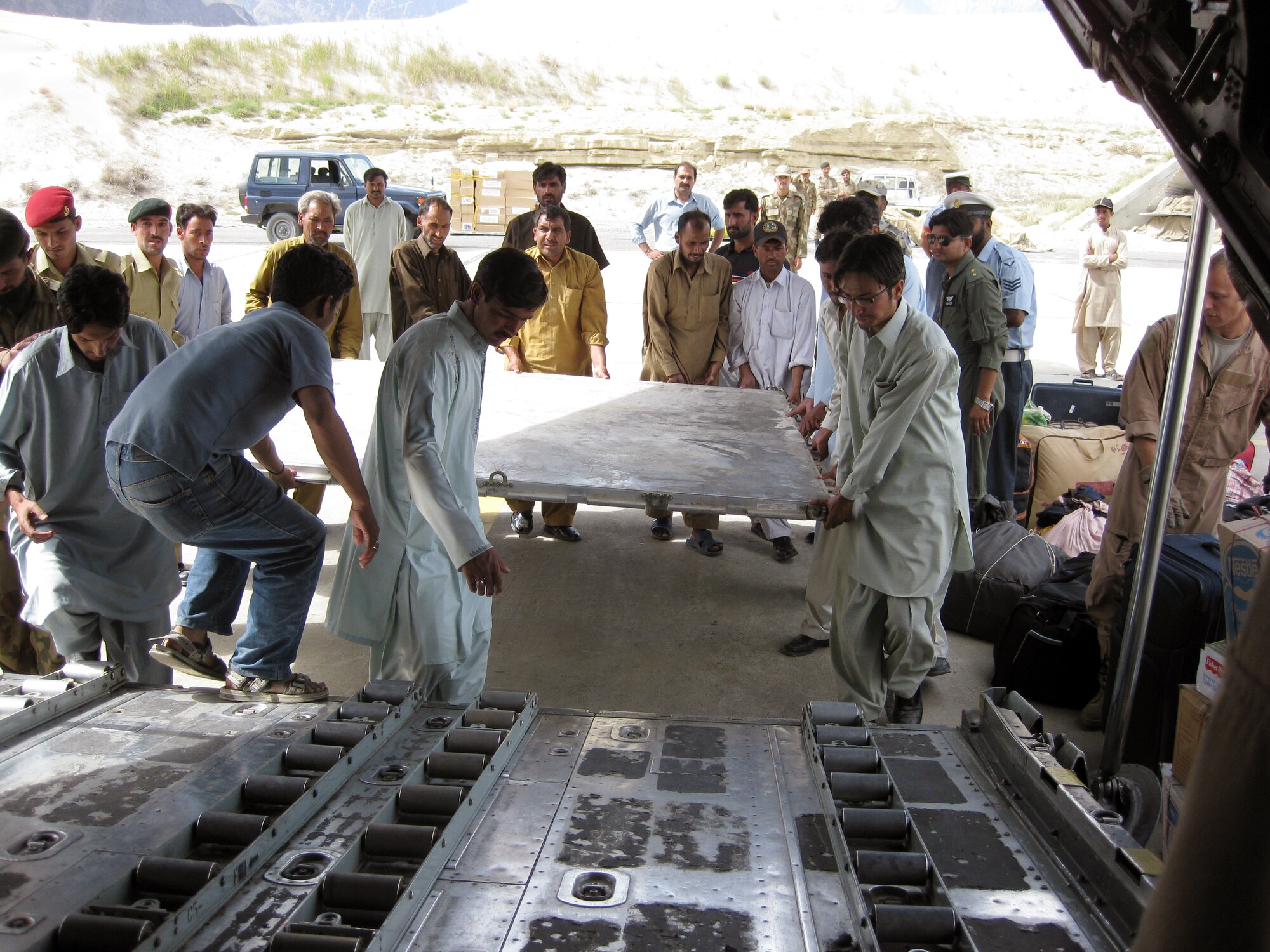 SOUTHWEST ASIA -- Pakistanis displaced by record flooding this summer prepare to palletize their personal luggage Sept. 5 before a flight out of Skardu Airport, Pakistan, aboard a U.S. Air Force C-130 aircraft. The passengers are among millions of Pakistani citizens who were forced from their homes in July and August following the worst monsoons in 80 years. The 386th Air Expeditionary Wing, including members from the 737th Expeditionary Airlift Squadron, deployed multiple C-130 aircraft and more than 80 personnel in response to the disaster, airlifting more than 1,000 tons of relief supplies and 500 displaced persons between Aug. 30, 2010, and Oct. 1, 2010, when the squadron's role in the mission concluded. (U.S. Air Force courtesy photo)