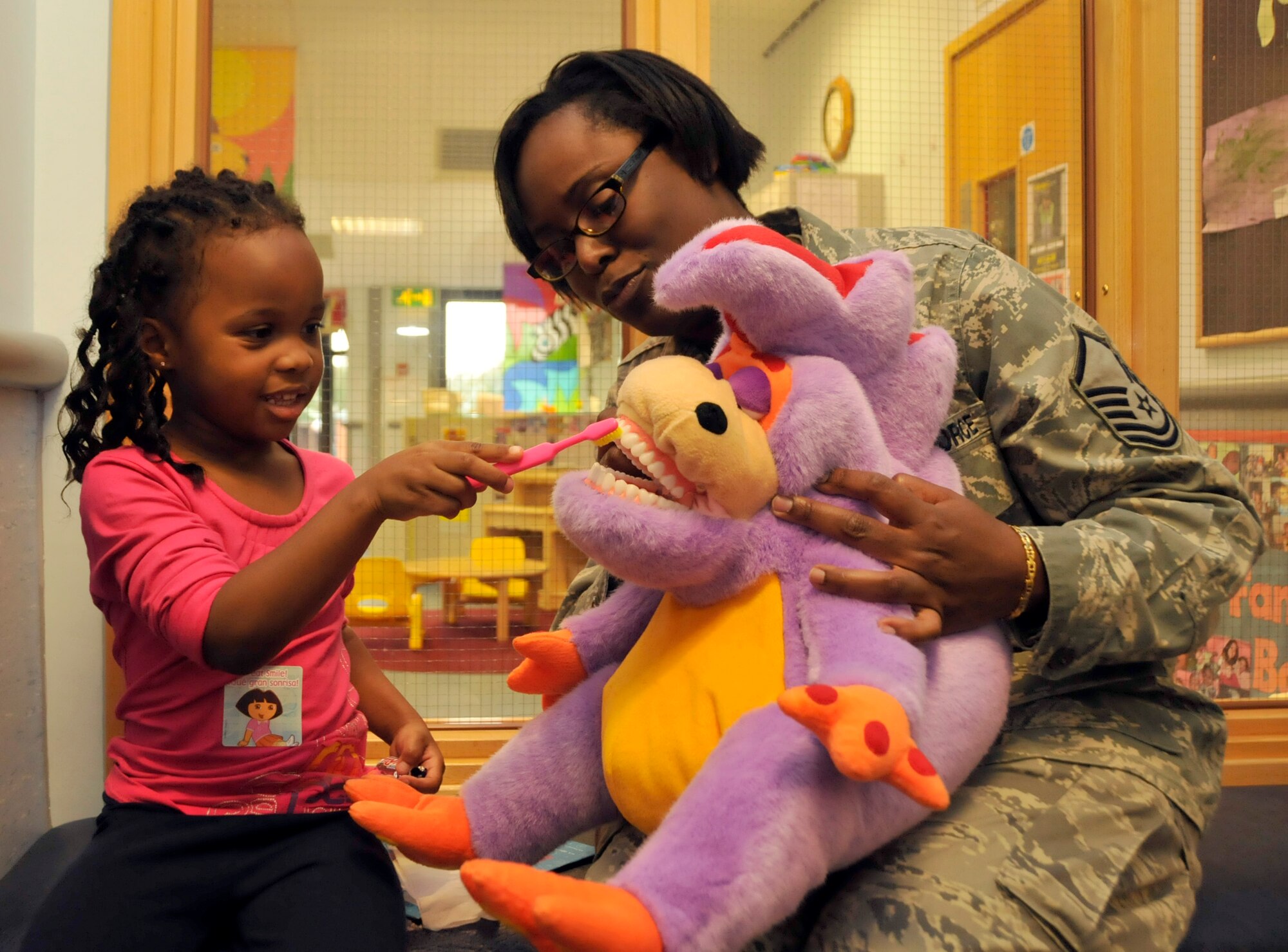 ROYAL AIR FORCE LAKENHEATH, England—Myla Toliver, 4-year-old, daughter of Maj. Ramone Toliver, 48th Medical Operations Squadron emergency physician, shows Master Sgt. Vicki Johnson, 48th Dental Squadron dental hygienist, how she brushes her teeth at the first health fair Oct. 6. Several clinics from the 48th Medical Group came together to educate parents and children about safety and wellness. (U.S. Air Force photo/Airman 1st Class Eboni Knox)

