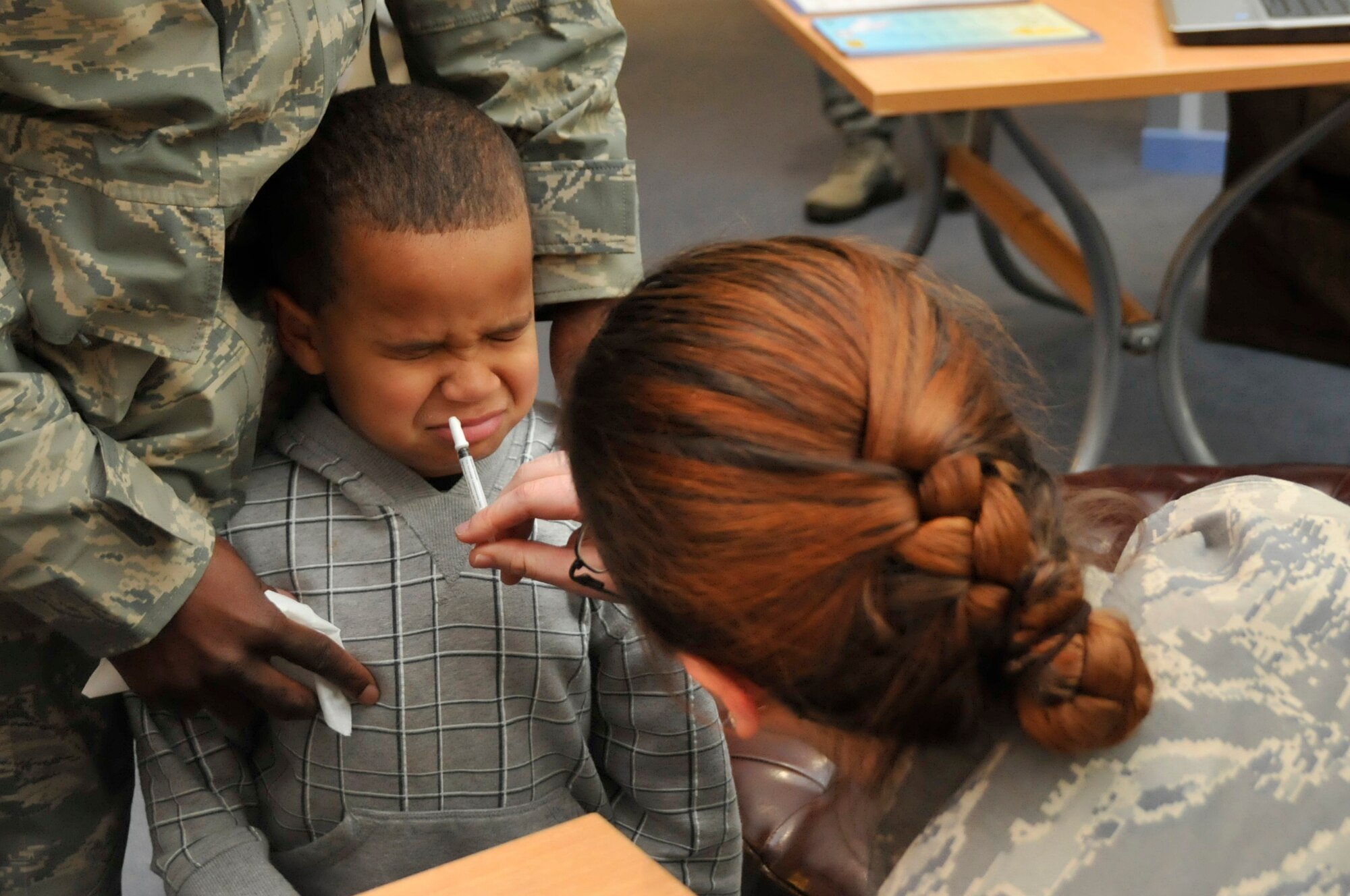 ROYAL AIR FORCE LAKENHEATH, England—3-year-old Julius McKinnon, 3-year-old, son of Staff Sgt. James McKinnon, 48th Munitions Squadron mission inspector, receives his annual flu mist during the first health fair at Child Development Center West on Oct. 6. The health fair rotated parents and children through six stations focusing on safety and wellness. (U.S. Air Force photo/Airman 1st Class Eboni Knox)