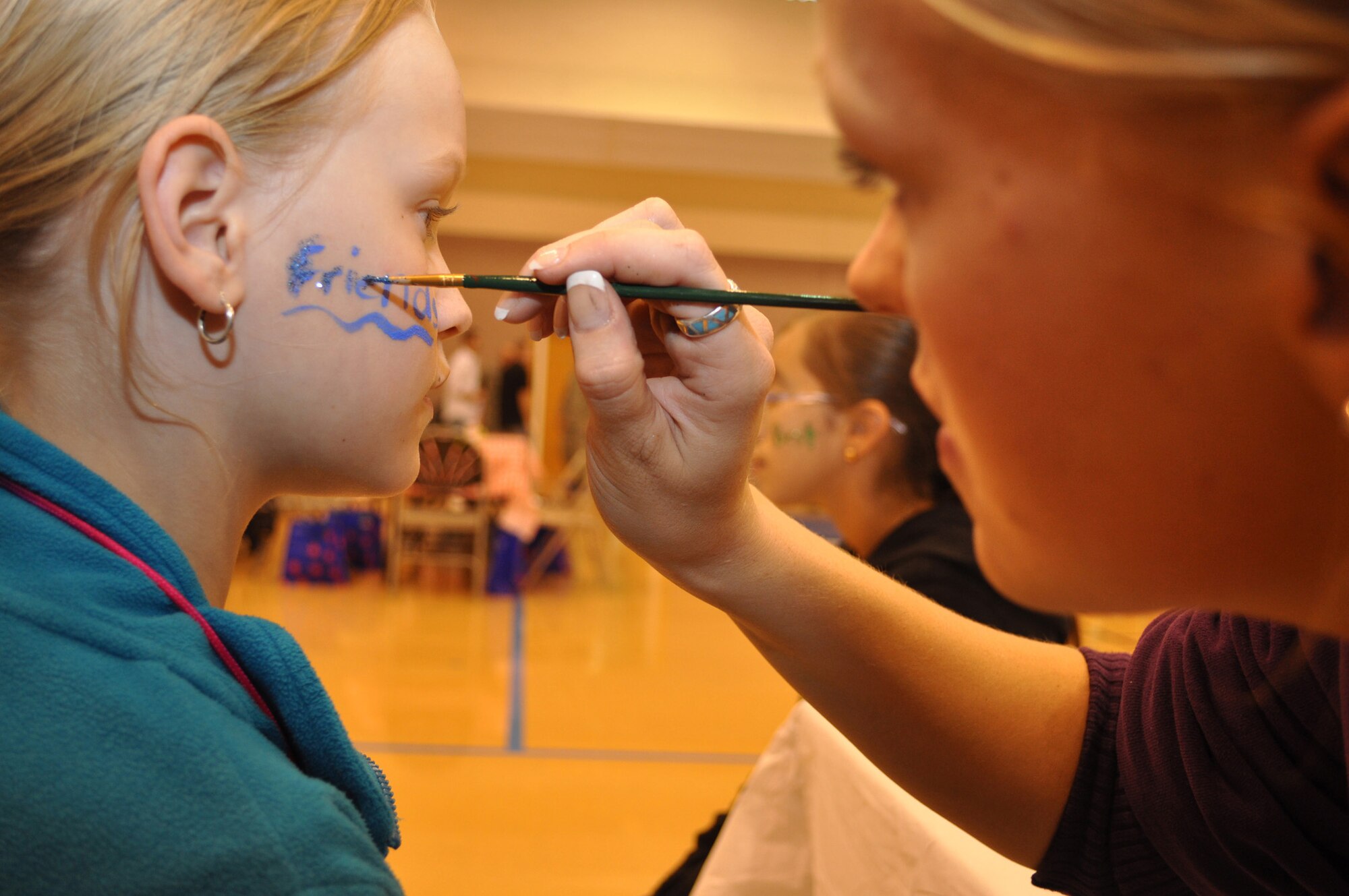 RAF MILDENHALL, England -- Best friends Anna Kirschling, 11, and in the background, Serena Rodriguez, 10, get their faces painted Aug. 26, 2010, at the Hearts Apart dinner for family members of active duty personnel who are deployed.  Serena's father, Master Sgt. Robert Rodriguez assigned to the 67th Special Operations Squadron, was the organizer of that event attended by more than 20 families.  Hearts Apart is one of several programs sponsored by the Airman and Family Readiness Center to support families with a deployed member.  (U.S. Air Force photo/Tech. Sgt. Marelise Wood)