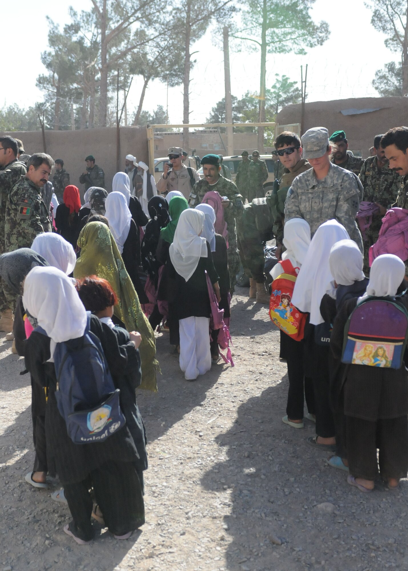 Shindand, Afghanistan – Shindand, Afghanistan – Female students wait in line to be presented the backpacks that soldiers and airman from base Shindand have put together for them.  (U.S. Navy photo by Mass Communication Specialist 3rd Class Jared E. Walker/ RELEASED).