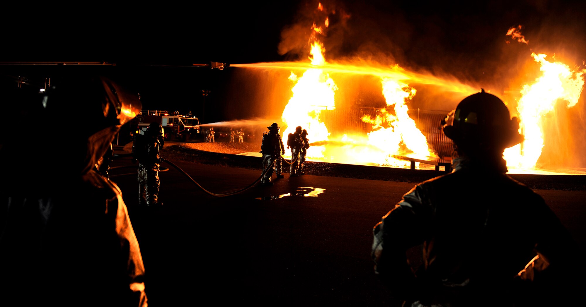 Firefighters from the 35th Civil Engineer Squadron at Misawa Air Base, Japan, extinguish a fire at a nighttime demonstration during Fire Prevention Week, Oct. 6, 2010. Fire Prevention Week was established to commemorate the Great Chicago Fire, that killed more than 250 people, left 100,000 homeless, destroyed more than 17,400 structures and burned more than 2,000 acres. (U.S. Air Force photo by Staff Sgt. Chad C. Strohmeyer/Released)