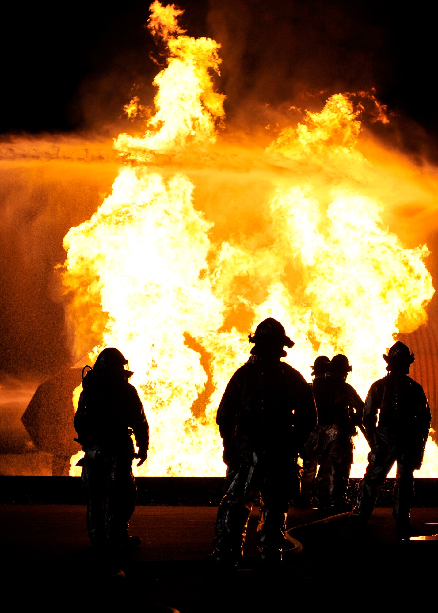 Firefighters from the 35th Civil Engineer Squadron at Misawa Air Base, Japan, extinguish a fire at a nighttime demonstration during Fire Prevention Week, Oct. 6, 2010. The fire engines used hold up to 3,000 gallons of water. (U.S. Air Force photo by Staff Sgt. Chad C. Strohmeyer/Released)