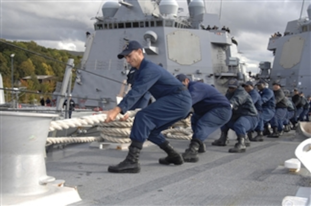 U.S. Navy sailors aboard the guided missile destroyer USS Bainbridge (DDG 96) haul in a mooring line while mooring the ship in Faslane, Scotland, on Sept. 30, 2010.  The Bainbridge is preparing to participate in Joint Warrior 10-2, a multinational exercise designed to improve interoperability between allied navies and prepare participating crews to conduct combined operations during deployment.  