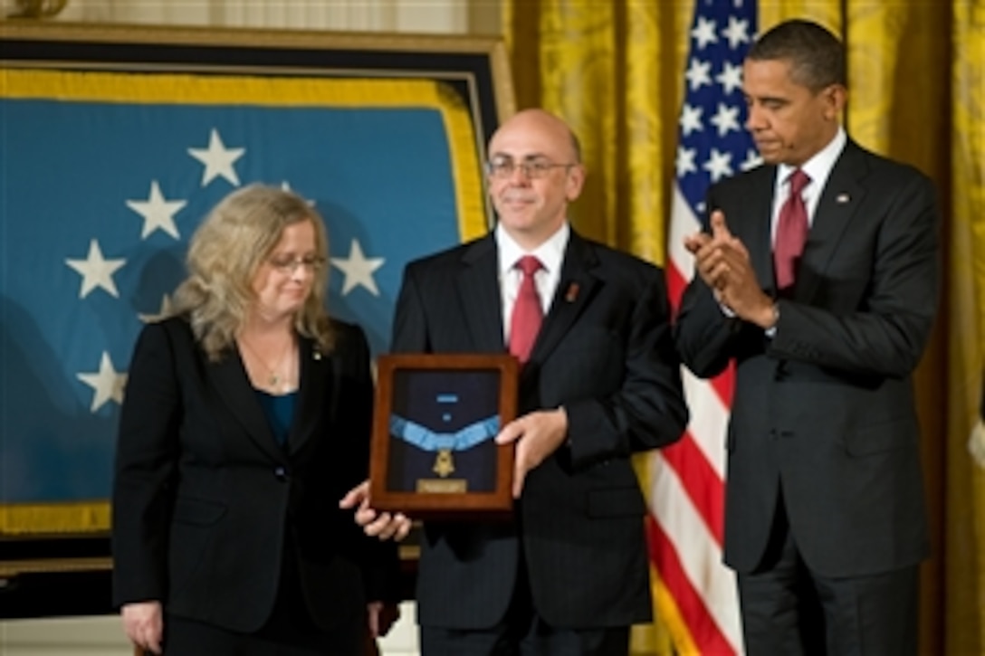 President Barack Obama presents the Medal of Honor posthumously to the parents of U.S. Army Staff Sgt. Robert J. Miller, father Phil and mother Maureen Miller, during a ceremony in the East Room of the White House in Washington, D.C., on Oct. 6, 2010.  Miller received the medal for his heroic actions in Afghanistan on January 25, 2008, after displaying immeasurable courage and uncommon valor eventually sacrificing his own life to save the lives of his teammates and 15 Afghanistan National Army soldiers.  