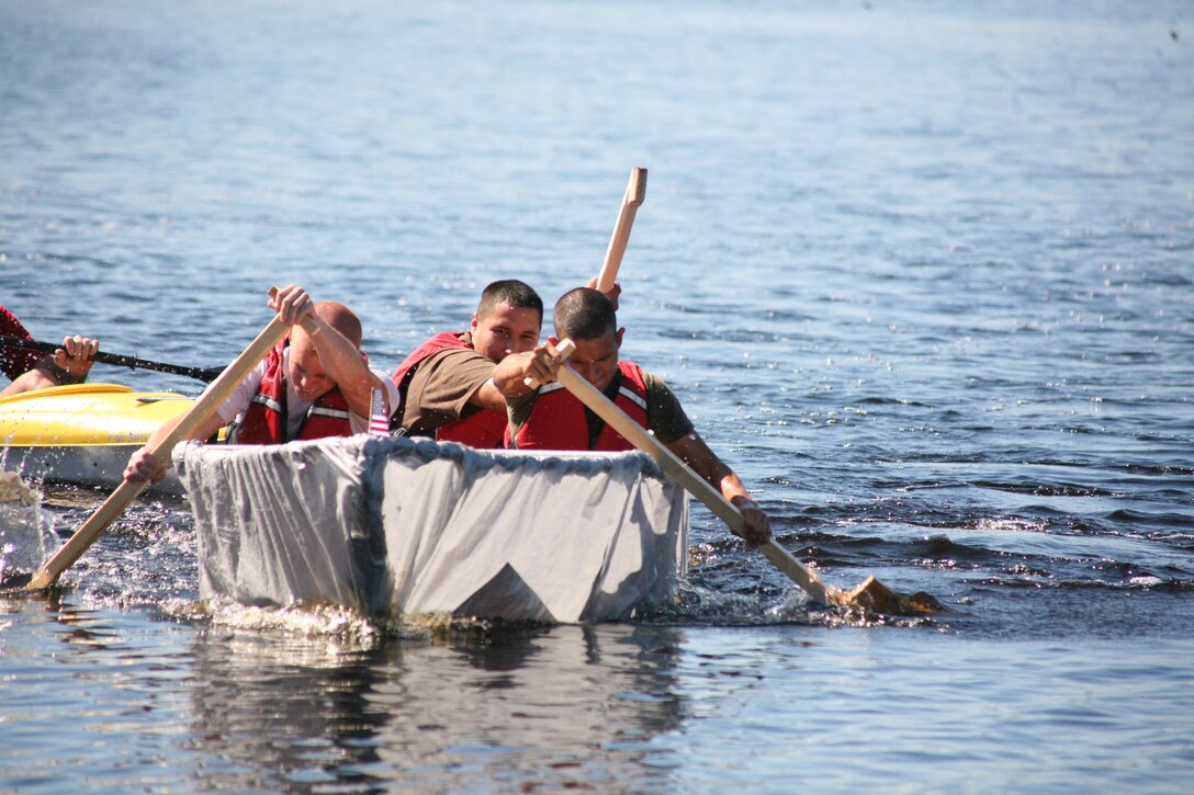 Lance Cpls. Leo Acuna and Cpl. Jared Braveheart and Lance Cpl. Jordan Friedman vigorously row to the finish line during a timed event in Marine Heavy Helicopter Squadron 366’s boat race Friday. The boat was constructed by flight line Marines with HMH-366. The flight line boat came in first place in the competition overall after a tiebreaking race and a referee call made in their favor.