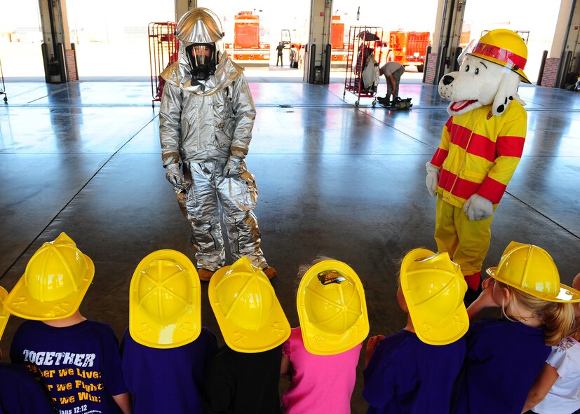 DYESS AIR FORCE BASE, Texas--Amn Tyler Ellie, 7th Civil Engineer Squadron firefighter and Sparky talk to Merkel Elementary students about bunker gear at the Fire Department here Oct. 8. Firefighters from the 7 CES gave kindergarteners from Merkel Elementary a tour of the fire department. . Students also were given demonstrations by the dog handlers at the K-9 unit. Dyess hosts tours throughout the year that are open to the public. For more information on tours call the Public Affairs office at (325) 696-4820. (U.S. Air Force photo/Airman 1st Class Chelsea Cummings)