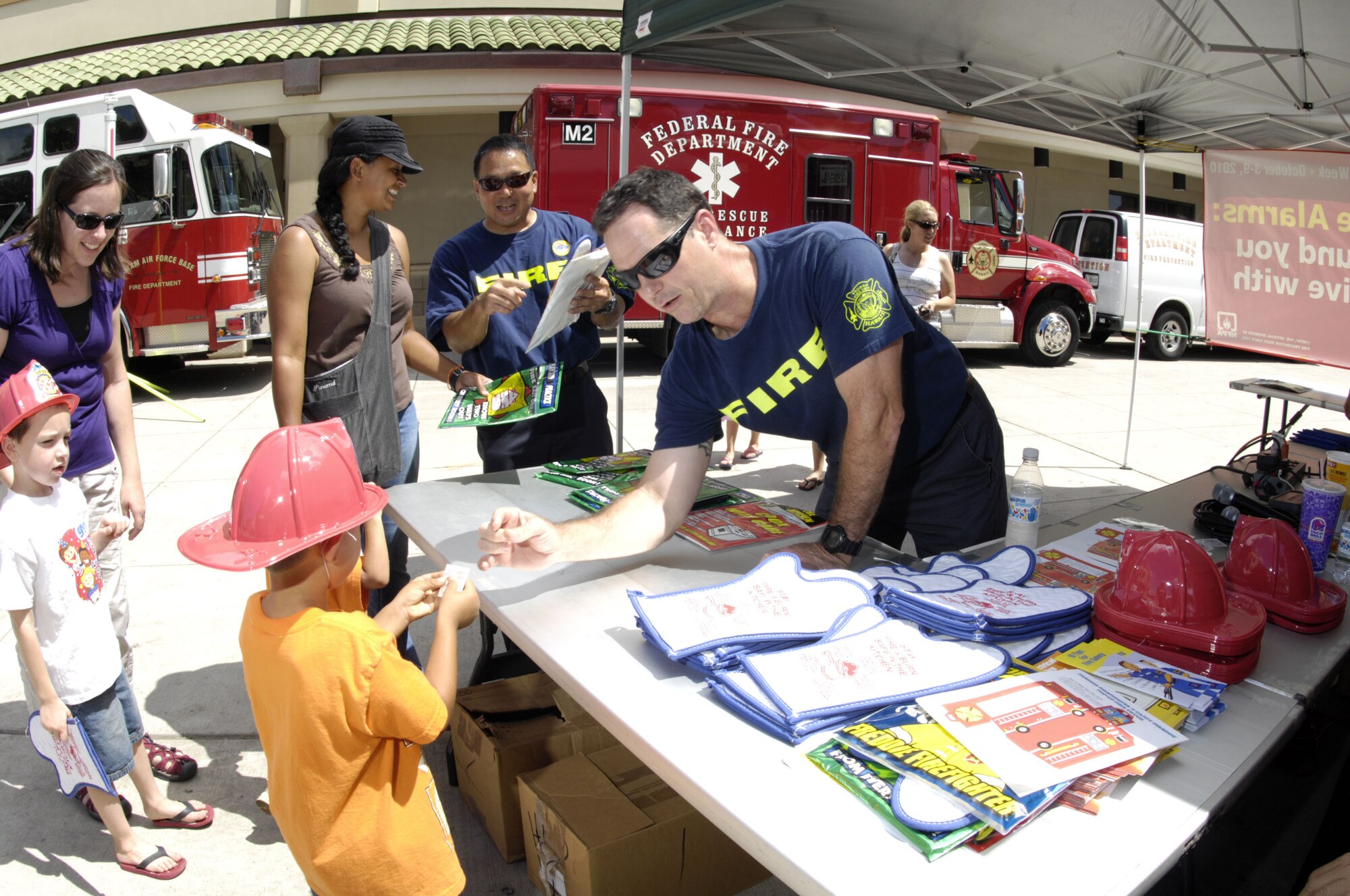 Scott Ebert, Federal Fire Department Fire Inspector, provides public information to patrons of the Navy Exchange Mall Complex Oct. 7.  The Federal Fire Department's Fire Prevention Division is increasing the public's awareness on the dangers of smoke and fire during Fire Prevention Week at Joint Base Pearl Harbor-Hickam, Hawaii.  (Photo by David D. Underwood, Jr.)