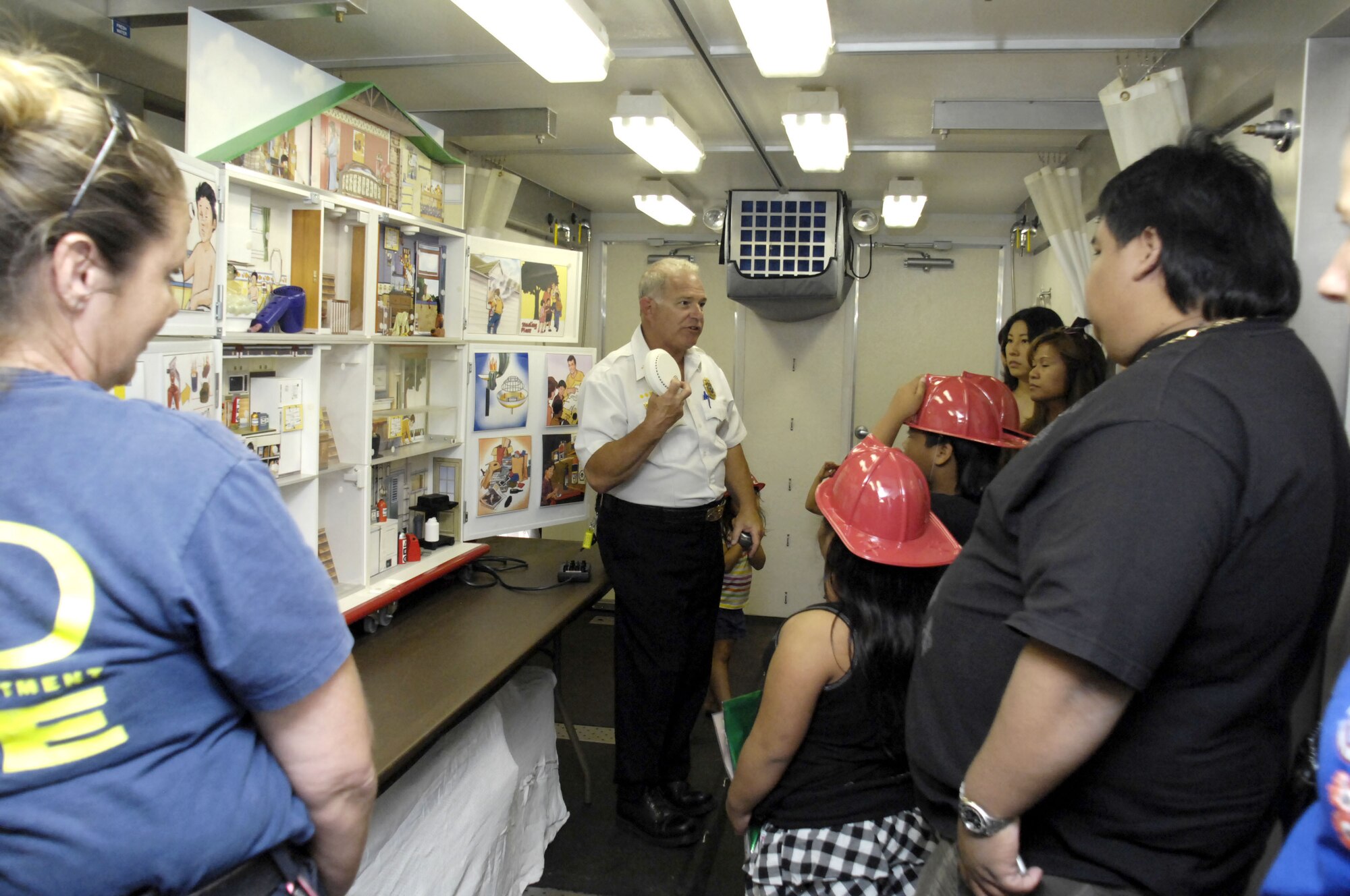 Mr. Victor Flint, Federal Fire Department Battalion Chief, explains the importance of a smoke detector to patrons of the Navy Exchange Mall Complex Oct. 7.  The Federal Fire Department's Fire Prevention Division is increasing the public's awareness on the dangers of smoke and fire during Fire Prevention Week at Joint Base Pearl Harbor-Hickam, Hawaii.  (Photo by David D. Underwood, Jr.)