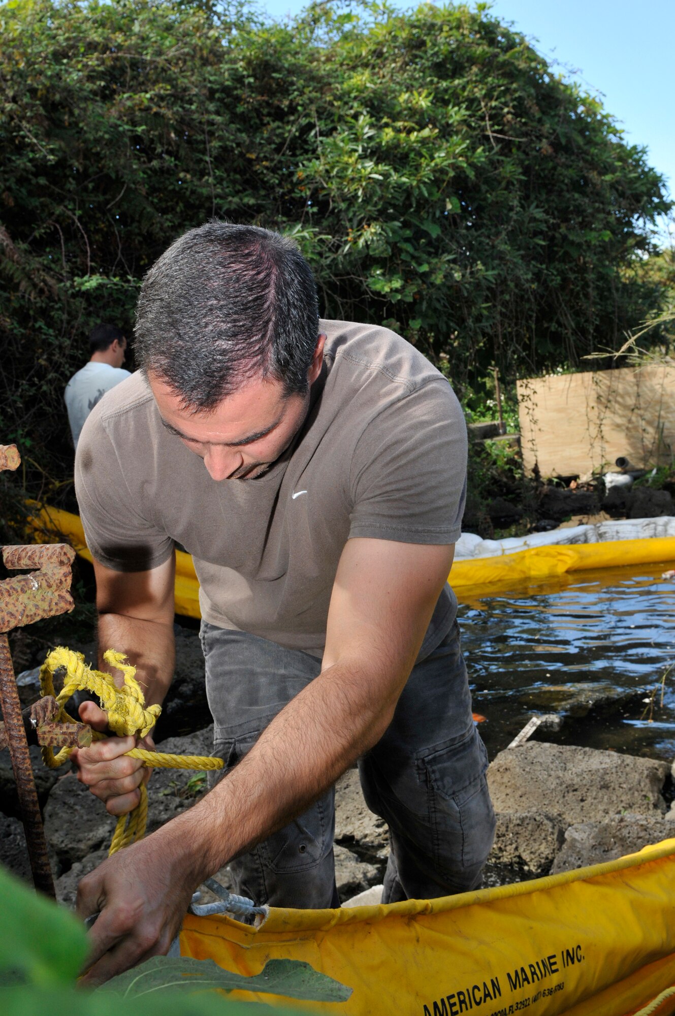 Marco Rosa anchors a boom for stability purpose during a land fuel spill training exercise Sept. 29, 2010, at Lajes Field, Azores. The joint exercise brought together more than 40 U.S. and host nation emergency response personnel in a classroom-discussion setting and hands-on scenarios. Mr. Rosa is from the 65th Civil Engineer Squadron . (U.S. Air Force photo/Staff Sgt. Olufemi Owolabi)