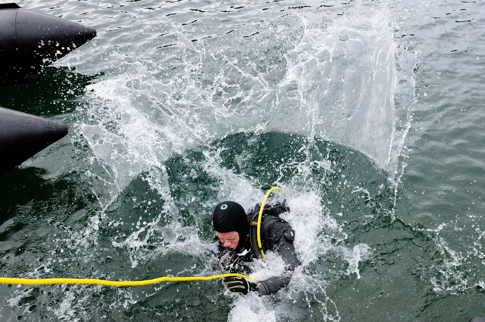 Senior Airman Nathan Simonson, 56th Rescue Squadron pararescueman, enters the water in preparation to conduct subsurface search patterns during rescue dive training Oct. 5, 2010, at Stoney Cove, England. The yellow rope was used between the diver and his wingman on land to relay line pull signals. (U.S. Air Force photo/Airman 1st Class Lausanne Morgan) 