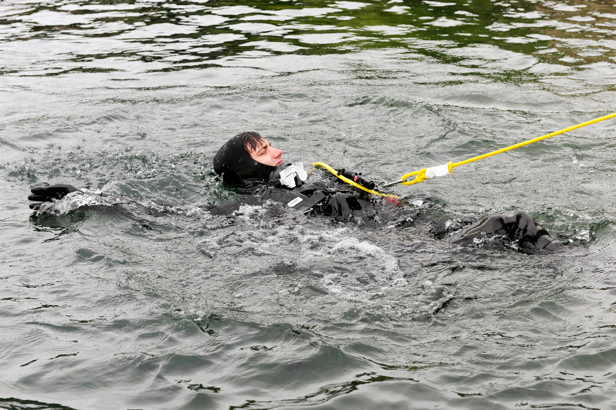 Senior Airman Eli Reynolds pulls tension on the line while surface swimming to his descent point for subsurface search, rescue and recovery training Oct. 5, 2010, at Stoney Cove, England. Before descending, dive instructors observe the diver for possible bubbles in their air manifolds. Senior Airman Reynolds is a 56th Rescue Squadron pararescueman. (U.S. Air Force photo/Airman 1st Class Lausanne Morgan)