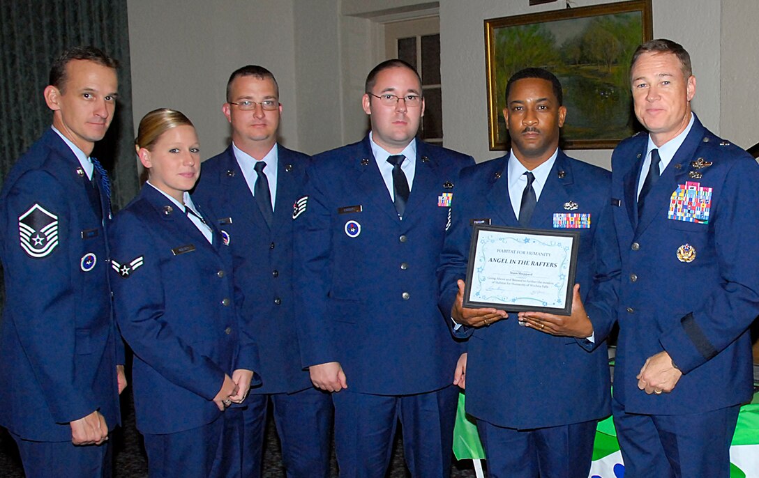 Brig. Gen. Darryl Burke, right, and other Sheppard Air Force Base Airmen accept the "Angels in the Rafters" award Oct. 7 during an event hosted by Habitat for Humanity.  Sheppard volunteers were recognized for their contributions to the non-profit organizations efforts to provide homes for low-income families. Also pictured with General Burke, 82nd Training Wing commander, include from left to right Master Sgt. Kevin Taylor, Airman 1st Class Adawn Kelsey, Tech. Sgt Michael Sirmons Jr., Staff Sgt. Michael Corbitt and Tech. Sgt. Christopher Flermius. (U.S. Air Force photo/Harry Tonemah)