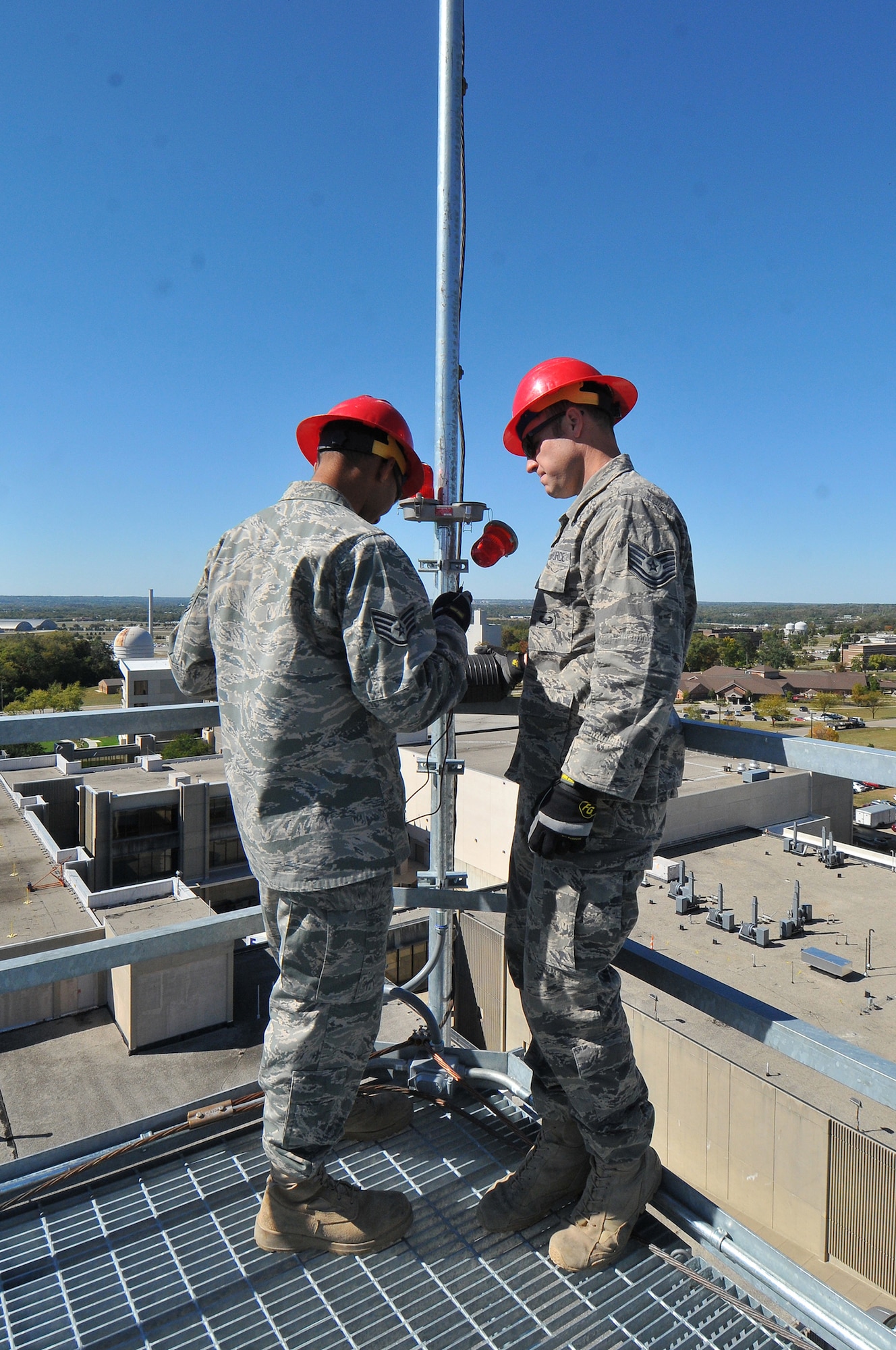Staff Sgt. Maurice Acosta and Tech. Sgt. Jordan Bunting inspect wiring atop a radar tower at Wright-Patterson Air Force Base, Ohio.  Active duty Airmen from the 820th RED HORSE Squadron at Nellis Air Force Base, Nev. and Air National Guard members from six states teamed in September to construct three 100-foot research radars towers for the Air Force Research Laboratory Sensors Directorate at Wright-Patt. The actual radars atop each tower were relocated from Rome, N.Y. to implement consolidation directed by BRAC 2005 decisions. Sergeants Acosta and Bunting are each with the 820th RHS Airborne Flight. (Skywrighter photo/Niki Jahns)