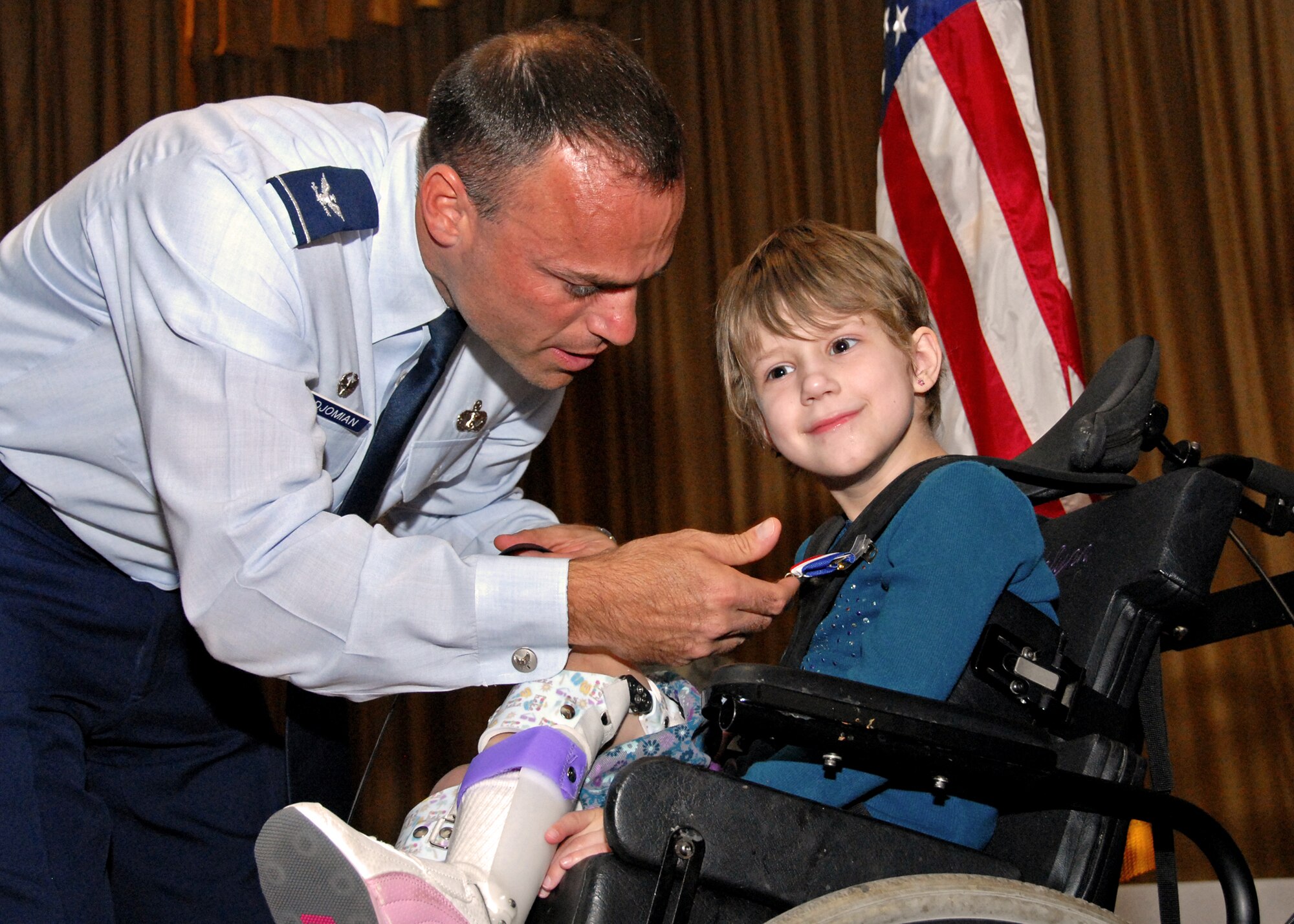 Col. Sal Nodjomian, commander of the 96th Air Base Wing, presents a "Home Front Hero" blue star medal to 8-year-old Lili Sparks. The Home Front Hero award recognizes children for contributions to their parents' successes in the military. (U.S. Air Force photo/Sachel Seabrook) 
