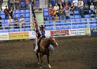 MINOT, N.D. -- Ms. Tiffany Kuntz, 2010 Ms. Rodeo North Dakota, of Bismarck, N.D., holds the American Flag during the opening ceremonies of the 2010 Y’s Men’s Rodeo here Oct. 7. The 56th annual Y’s Men’s Rodeo is being held at the North Dakota State Fairgrounds through Sunday, Oct. 10 with all proceeds from the rodeo benefiting the YMCA’s Triangle Y camp located near Garrison, N.D. Military appreciation day is Sunday, Oct. 10. All military members, family members and retirees receive half off of the ticket price with a military ID. Tickets may be purchased at the Dakota Square Mall ticket booth or at the North Dakota State Fair Center ticket booth. (U.S. Air Force photo by Staff Sgt. Keith Ballard)