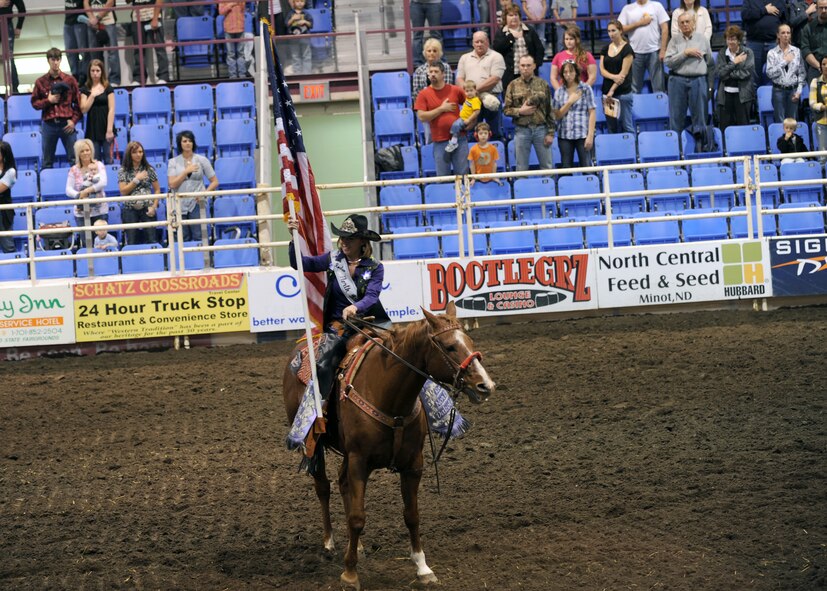 MINOT, N.D. -- Ms. Tiffany Kuntz, 2010 Ms. Rodeo North Dakota, of Bismarck, N.D., holds the American Flag during the opening ceremonies of the 2010 Y’s Men’s Rodeo here Oct. 7. The 56th annual Y’s Men’s Rodeo is being held at the North Dakota State Fairgrounds through Sunday, Oct. 10 with all proceeds from the rodeo benefiting the YMCA’s Triangle Y camp located near Garrison, N.D. Military appreciation day is Sunday, Oct. 10. All military members, family members and retirees receive half off of the ticket price with a military ID. Tickets may be purchased at the Dakota Square Mall ticket booth or at the North Dakota State Fair Center ticket booth. (U.S. Air Force photo by Staff Sgt. Keith Ballard)