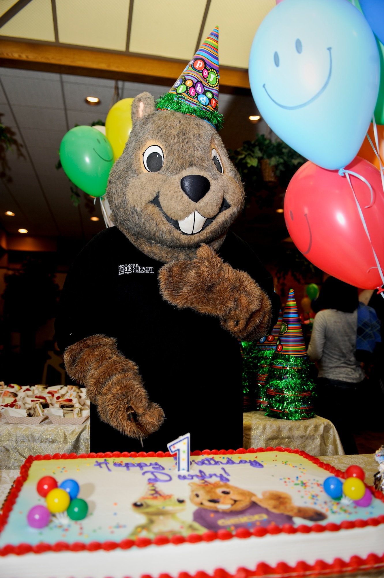 MINOT AIR FORCE BASE, N.D. -- Darby, the 5th Force Support Squadron mascot, poses with his cake during his birthday party at the community center here Oct. 7. Darby has served the Minot AFB community for more than 21 years. Other mascots who came to support Darby on his day of celebration included: McGruff the Crime Dog, Sparky the Fire Dog, Ready Freddy and Minot State’s Buckshot. (U.S. Air Force photo by Senior Airman Benjamin Stratton)