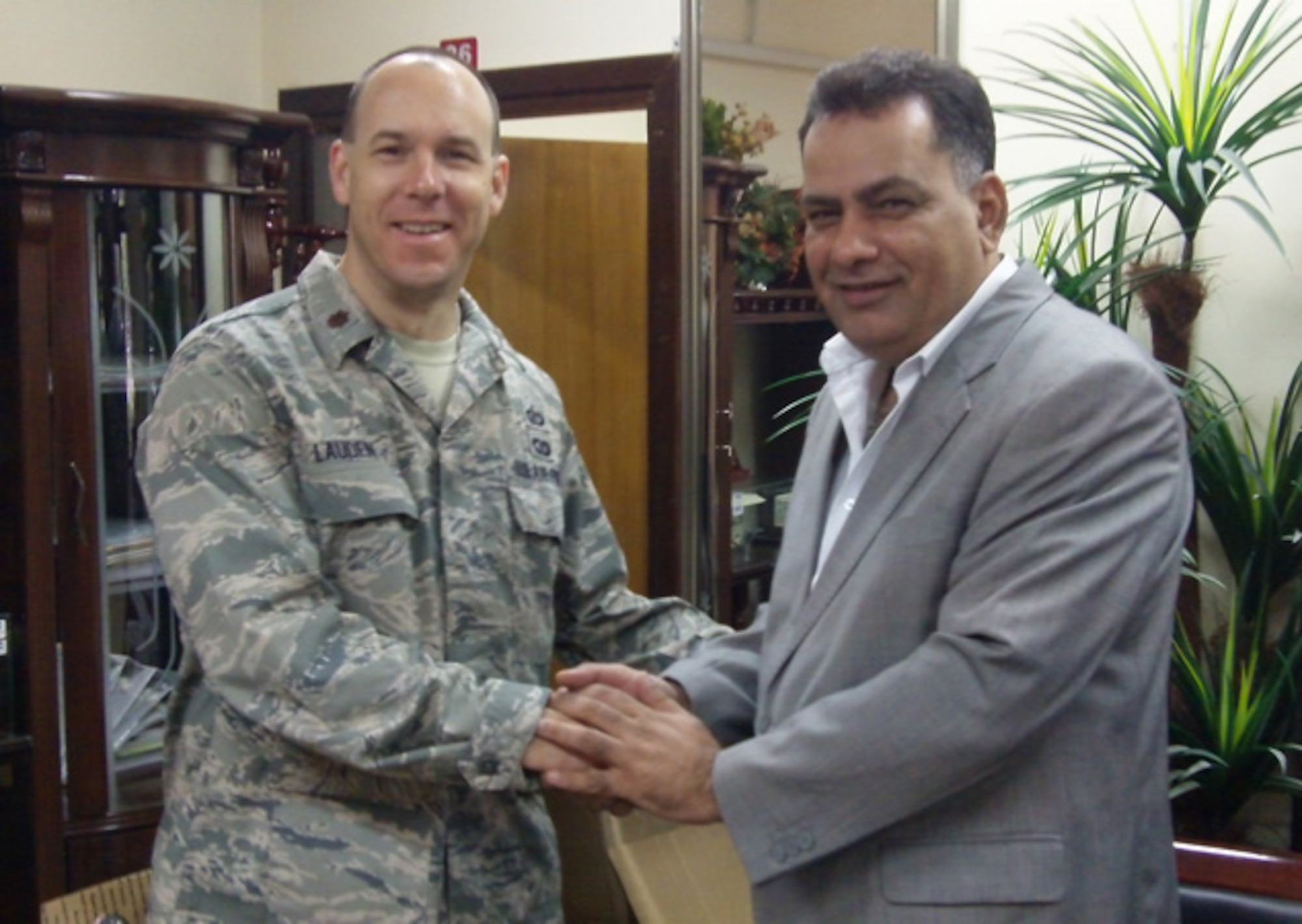 Maj. Michael Lauden, director of operations for ESC’s Air Force Distributed Common Ground Systems Division, currently deployed in Iraq, is thanked by Mazin Zayer Al-Lamy, director general for Contracts and Sales in the Iraqi Ministry of Defense, for the support he provided in collecting donations for the family of Mr. Al-Lamy's driver, who had passed away after being shot by an insurgent. (Courtesy photo)  