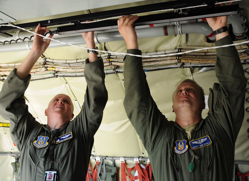 MacDill Air Force Base, Fla. --  Colonel Thom Pemberton, operations commander for the 927 Air reserve Wing, stands beside Maj. Barry Van Sickle, a member of the 45th Aeromedical Evacuation Squadron.  The two officers worked alongside enlisted men learning how to install a prototype lighting system aboard a KC-135 recently.  The lighting system will aid aeromedical evacuation missions by providing much-needed light to medical personnel. (Official United States Air Force photo by Staff Sgt. Shawn C. Rhodes)