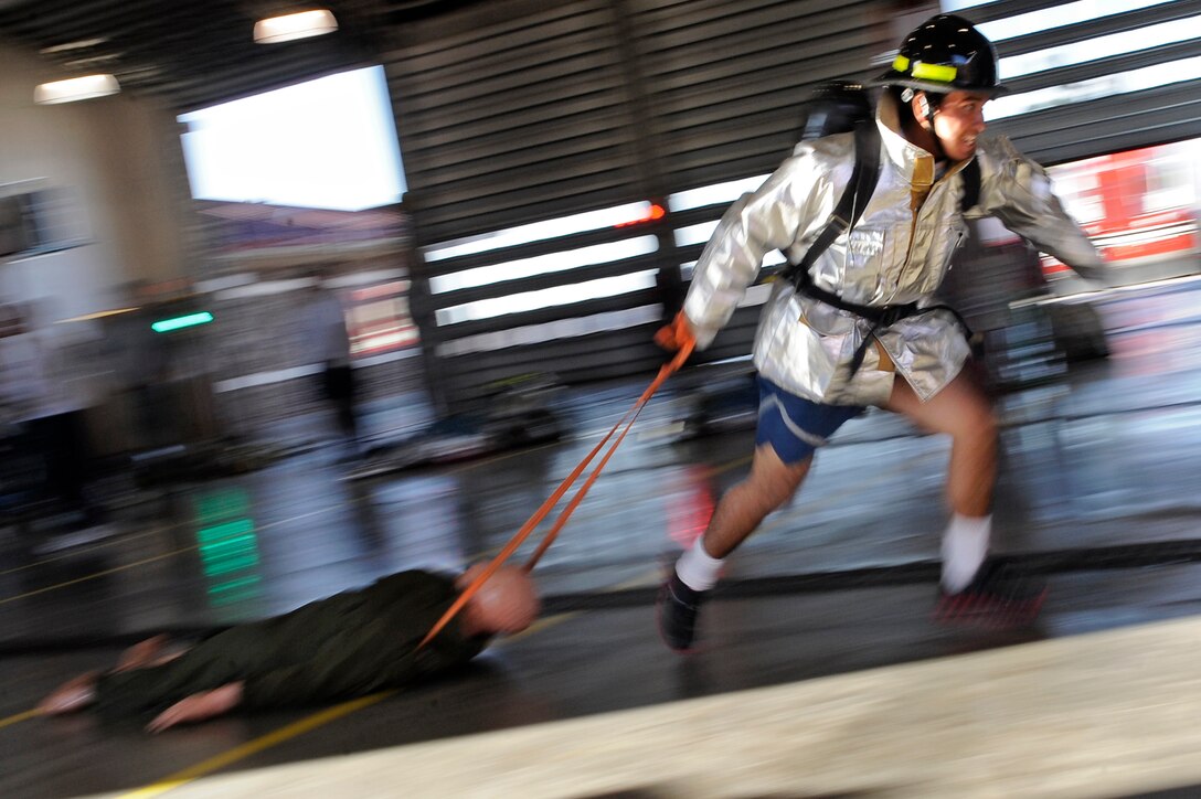 ELLSWORTH AFB, S.D. - Airman 1st Class Allan Rosales, 28th Civil Engineer Squadron electrician, carries a hose up a flight of stairs during the 2010 Ellsworth Firefighter Challenge, Oct. 1.  Airman Rosales and his team from the 28th CES electric shop won the competition with a time of 3:56. (U.S. Air Force photo/Staff Sgt. Marc I. Lane)