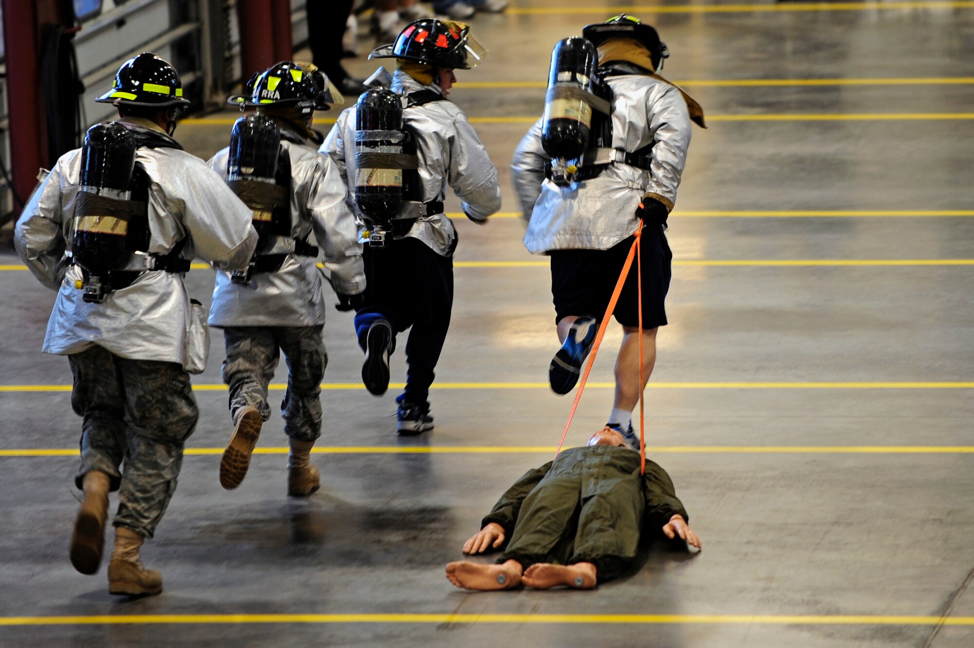 ELLSWORTH AFB, S.D. - A team of Airmen from the 28th Civil Engineer Squadron fire department run together during the dummy drag portion of the 2010 Ellsworth Firefighter Challenge, Oct. 1.  The firefighter challenge gave ten teams of Airmen, from across Ellsworth AFB, a brief idea of the strenuous activities for which firefighters must train. (U.S. Air Force photo/Staff Sgt. Marc I. Lane)