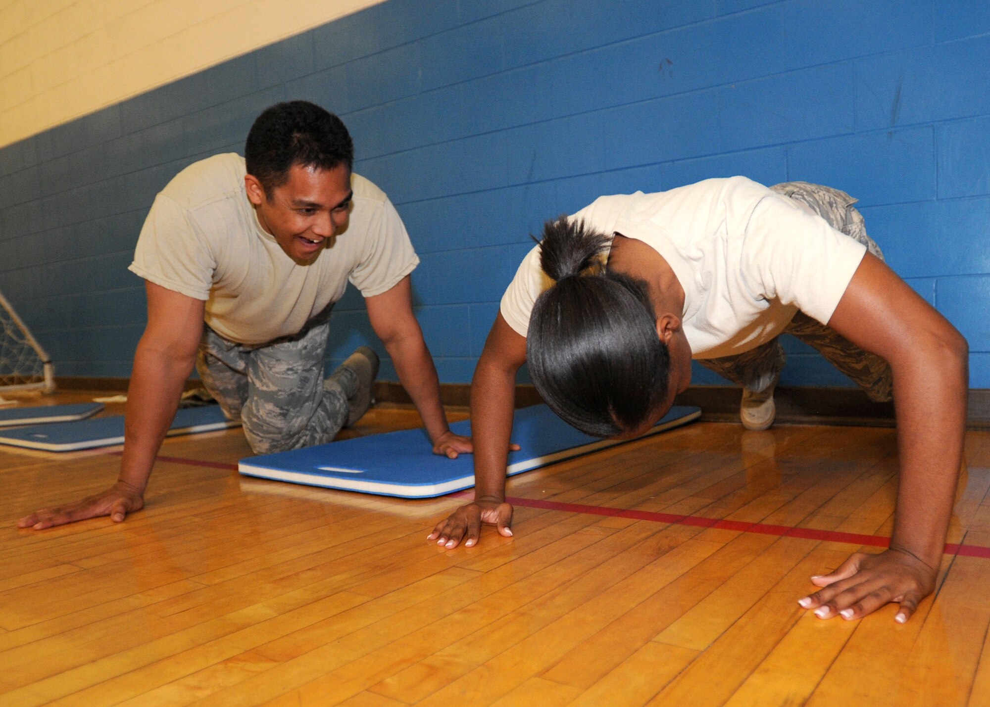 Staff Sgt. Lawrence Cabusca, 27th Special Operations Equipment Maintenance Squadron, encourages Staff Sgt. Sandra Williams, 27 SOEMS, during the 10-minute push up race Oct. 8. Sergeant Cabusca finished with 193 push ups while Sergeant Williams 174. (U.S. Air Force photo by Senior Airman Maynelinne De La Cruz)