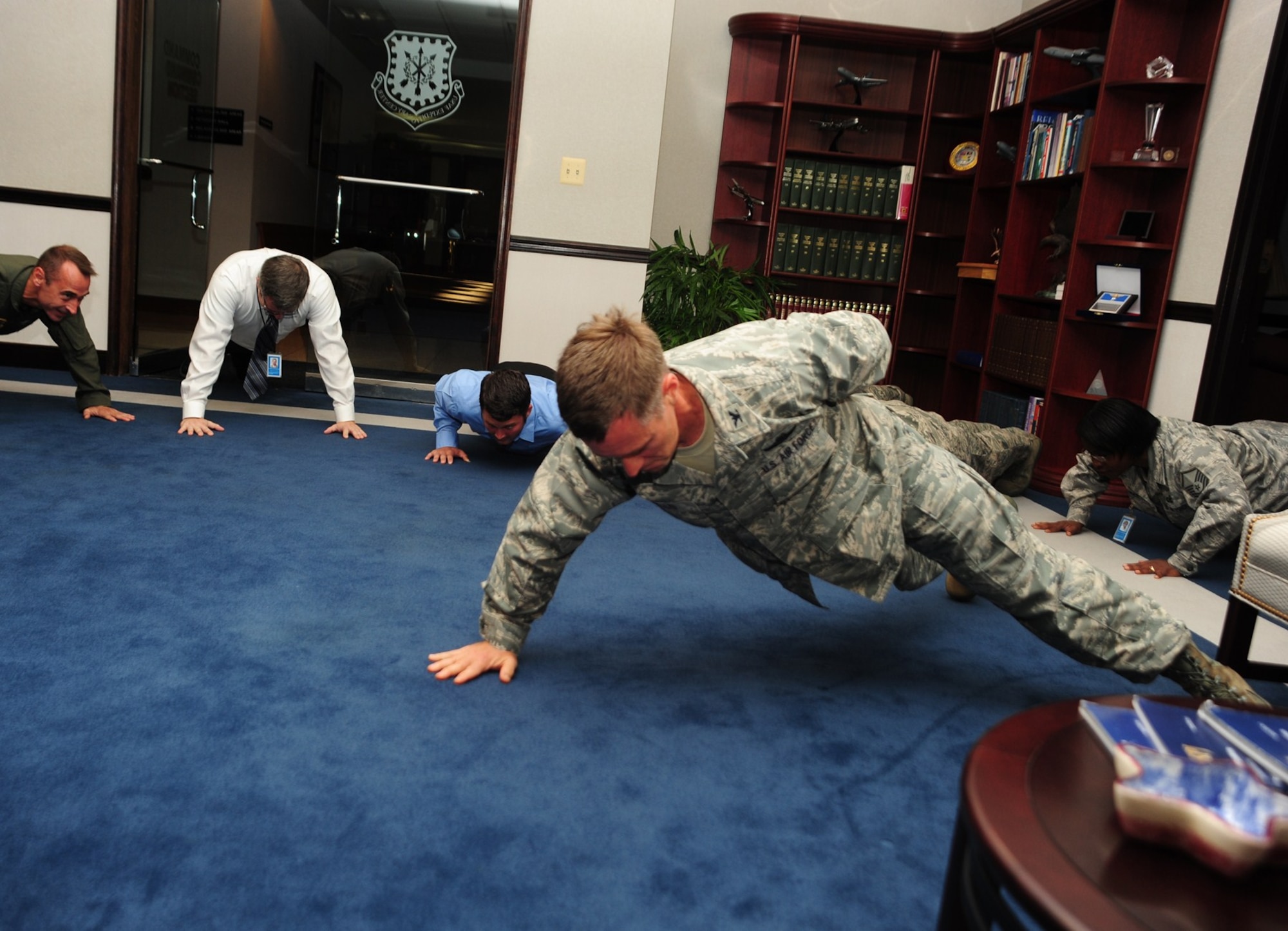 Col. Mark Ellis, Expeditionary Operations School commandant at the U.S. Air Force Expeditionary Center performs push-ups in the EC command section during the Center's Ground Up Fitness Challenge at Joint Base McGuire-Dix-Lakehurst, N.J. recently. Students and faculty at the Expeditionary Center perform sets of pushups and sit-ups at designated times each day as part of the organization's overall commitment to installing a commitment to fitness. (U.S. Air Force photo by Staff Sgt. Zachary Wilson/Released)