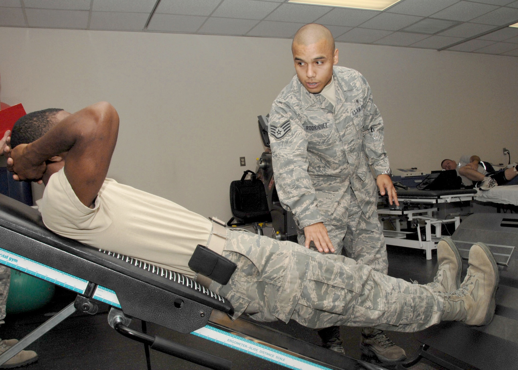 Staff Sgt. Vicente Rodriguez, a physical therapist with the 59th Medical Wing, works with a patient on an exercise machine Oct. 5, 2010, at Wilford Hall Medical Center at Lackland Air Force Base, Texas.  As a safe and effective alternate to prescription drugs, physical therapists design a regimen of evidence-based physical treatment programs to meet the needs of patients according to injury. (U.S. Air Force photo/Harold China)