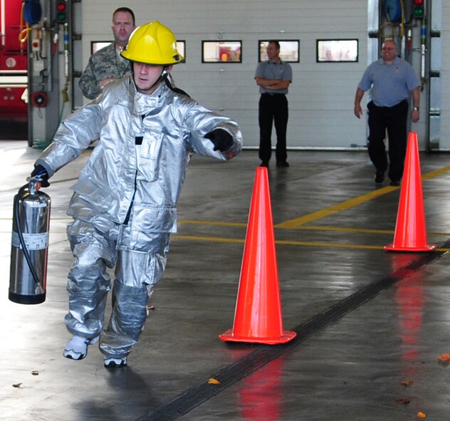 RAF MILDENHALL, England -- Staff Sgt. Scott McClure, 100th Maintenance Squadron, runs through cones with a fire extinguisher during the individual event at the fire muster Oct. 7, 2010, at the fire department. Members from squadrons around base participated in the Fire Prevention Week event both in team and individual events. (U.S. Air Force photo/Karen Abeyasekere)