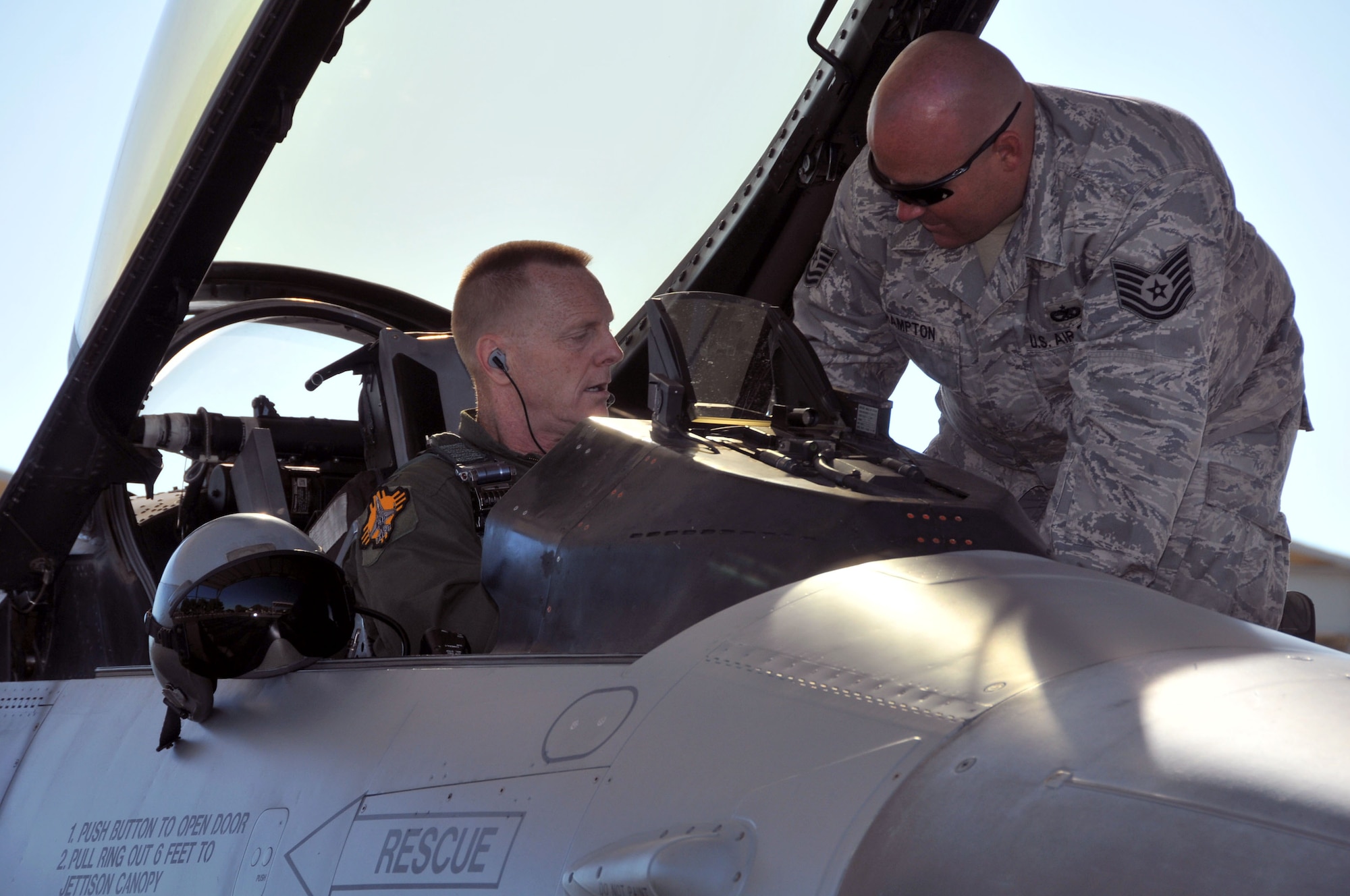 Staff Sgt. Hampton and Col. Frederik Hartwig, both from the 150th  Fighter Wing, New Mexico Air National Guard, go through a checklist prior to the final two F-16s takeoff from the Air Guard Sunday, Sept. 26, 2010 on Kirtland Air Force Base. (U.S. Air Force photo by Master Sgt. Paula Aragon) 
