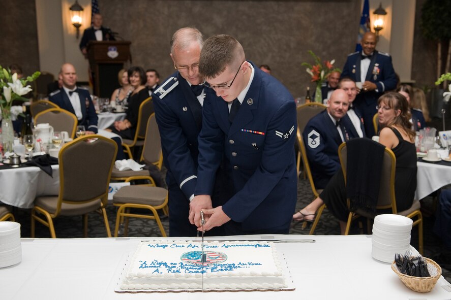 Col. Robert Mendenhall, 341st Security Forces Group commander, and Airman 1st Class Matthew Tobin, 341st Missile Maintenance Squadron, cut the cake in traditional style with a sabre. (U.S. Air Force photo/Beau Wade)