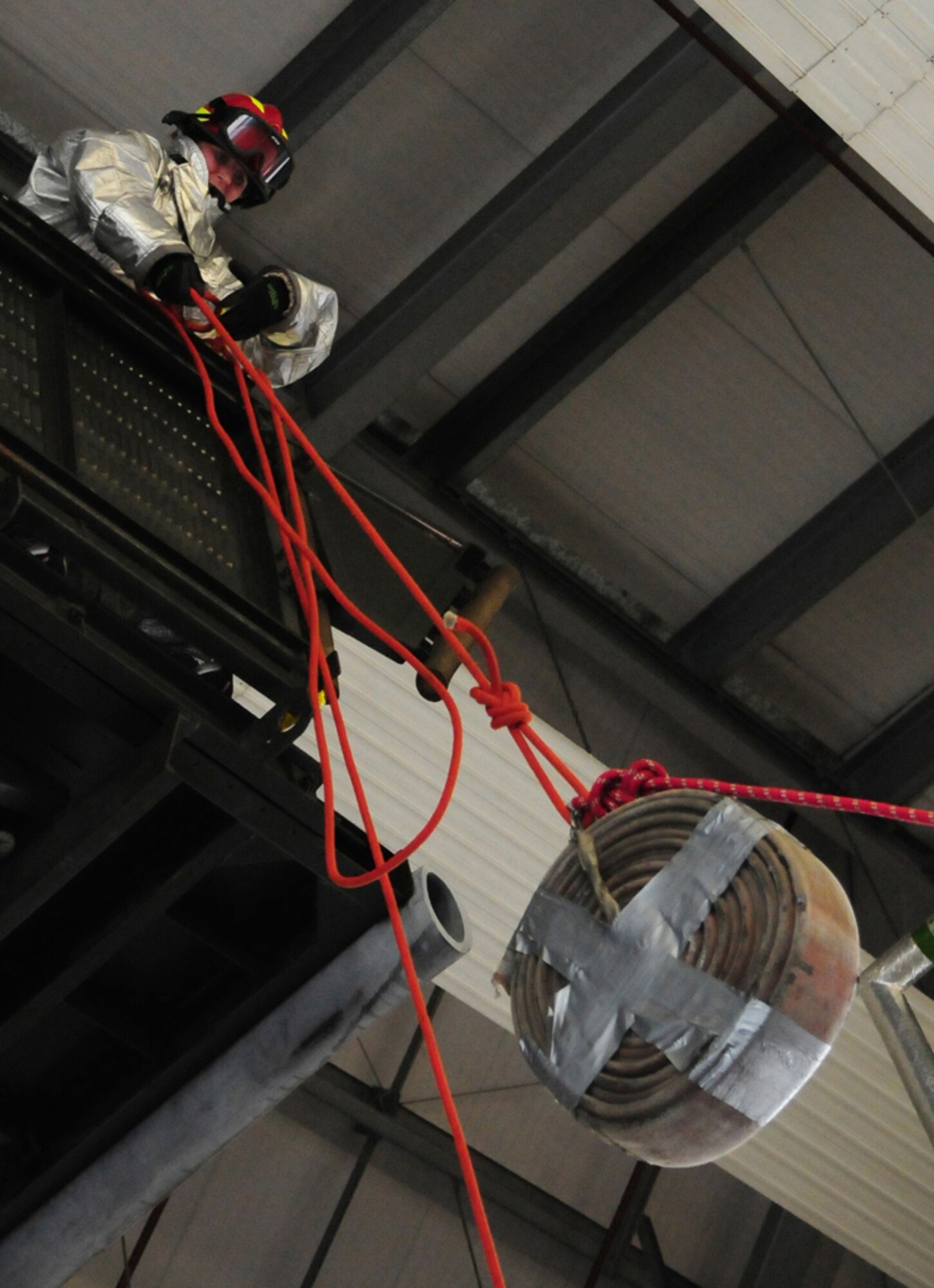 RAF MILDENHALL, England -- Laura Reynolds, 100th Force Support Squadron and team member of the "CPF (Civilian Personnel Flight) Belles" hoists up a donut hose during the fire muster Oct. 7, 2010, held as part of fire prevention week. Team Mildenhall members signed up for both team and individual events, which as well as the hose hoist, included the Kaiser sled, fire extinguisher run and dummy drag. The team events each finished with all members having to fill buckets of water, throwing it over a "burning" house, when the water went down a drainpipe and eventually filled a water-butt. Ms. Reynolds place first in the individual female event (U.S. Air Force photo/Karen Abeyasekere) 